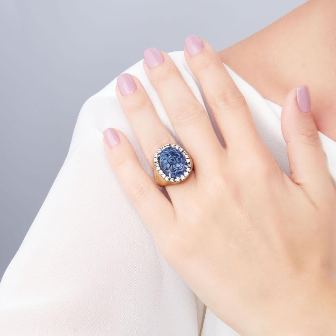 The vivid Blue colour of the finely carved Sapphire of the Ring “Candy” for 25,68 carats, enhanced by a dazzling entourage of 1,21 carats Brilliant-cut Diamonds, G-H colour, IF-VS clarity, stands out on the brushed 18 kt Yellow Gold setting.