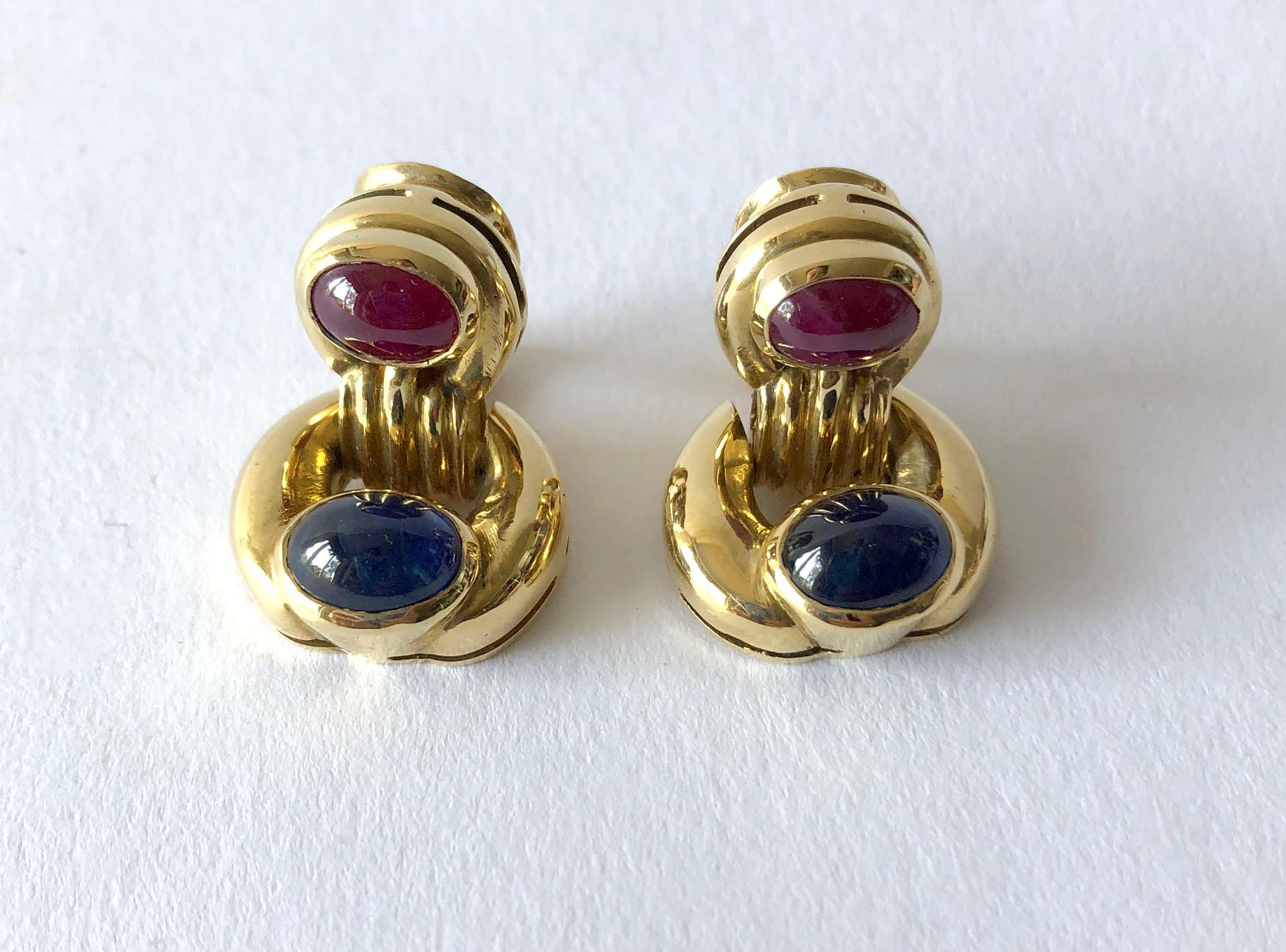 Door knocker earrings featuring oval-shaped ruby and sapphire cabochons set in 18k gold.  Earrings measure 1  1/8
