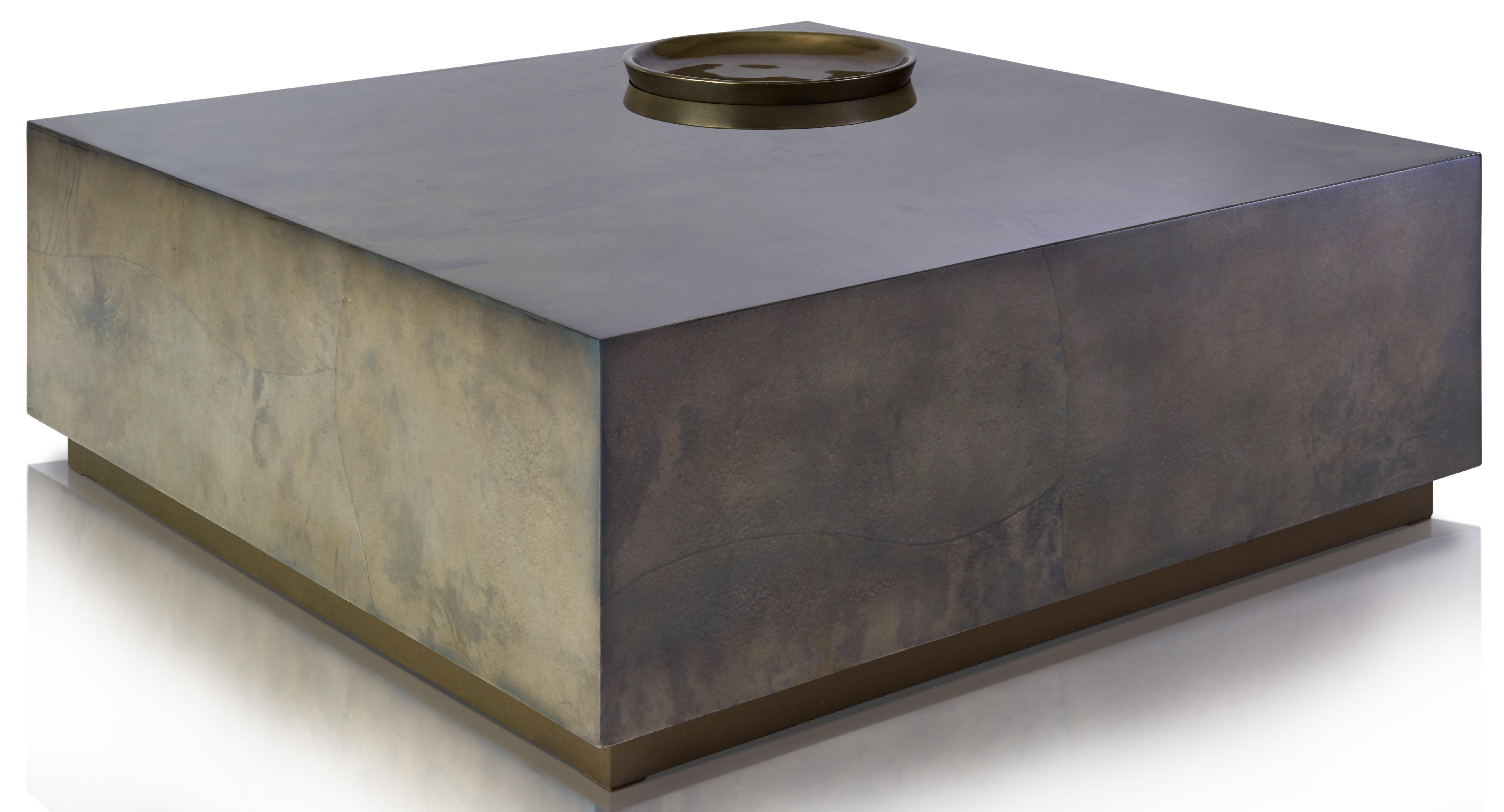 This chic coffee table is beautifully crafted by master artisans and features an inset sculptural bowl and trims in metallic pewter leaf. 

The classic aesthetic is finished with handcrafted parchment in midnight blue or moon shadow grey.