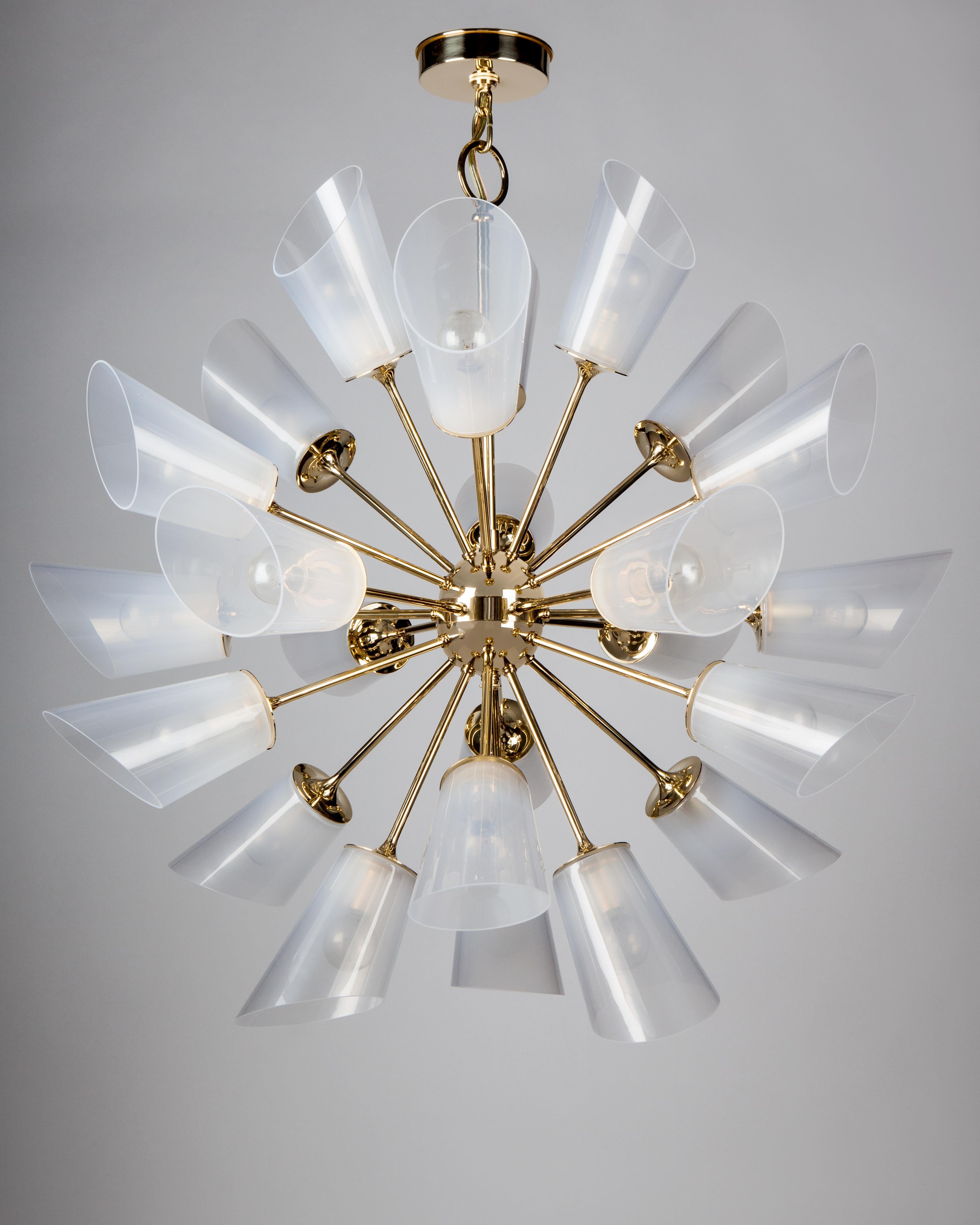 HL3000.24
The Vesta 24 chandelier by Remains Lighting is a modern Sputnik style ceiling fixture with 24 long slender precisely cut arms emanating from a central orb. The flared ends hold angular hand blown translucent glass shades, each with unique