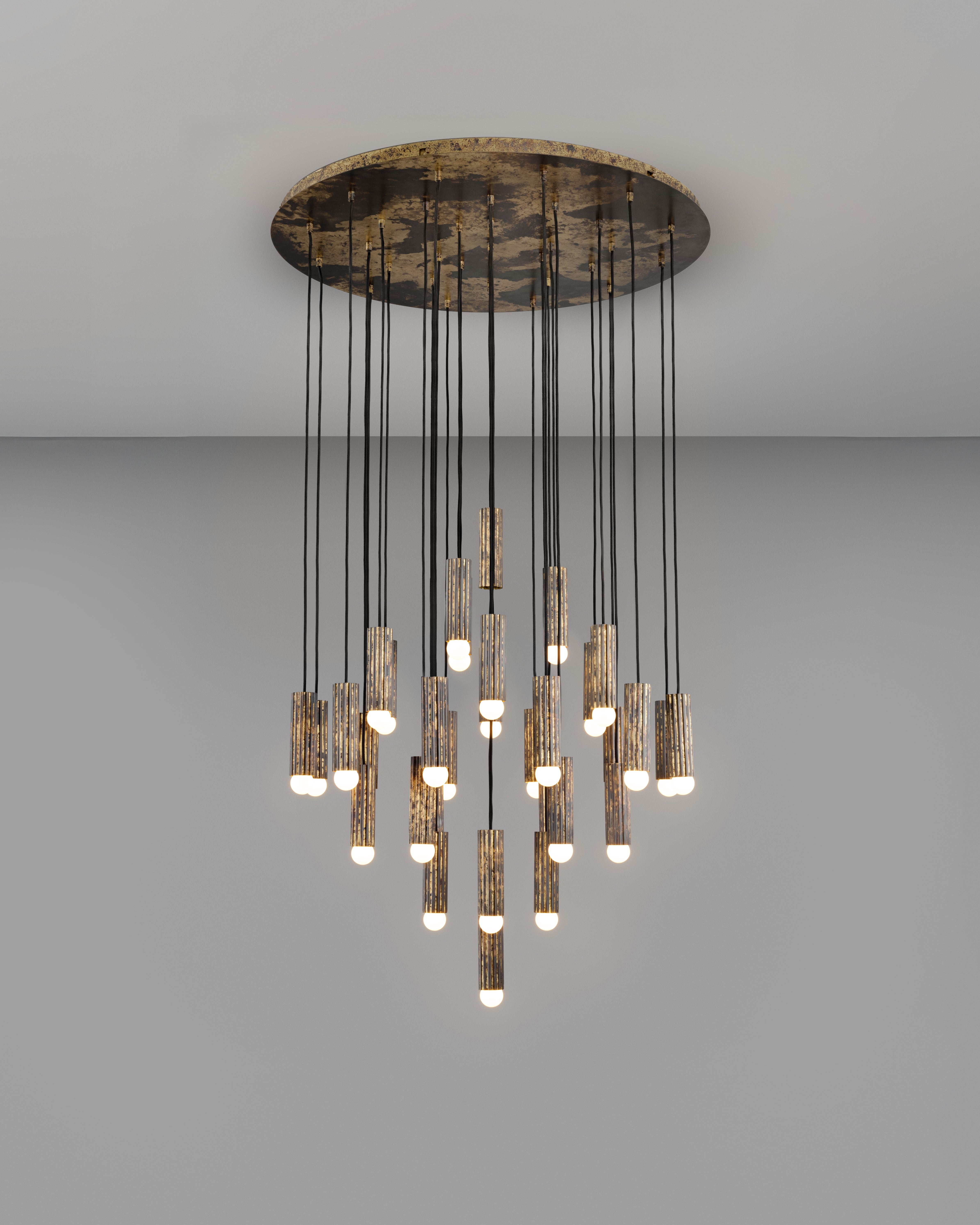 Thirty-two fluted solid brass cylinders are suspended in diamond formation, and a constellation hovering in space. From the side, vertical lines unfold in suspended harmony; from below, a celestial map of light emerges. Sculptural, commanding, and