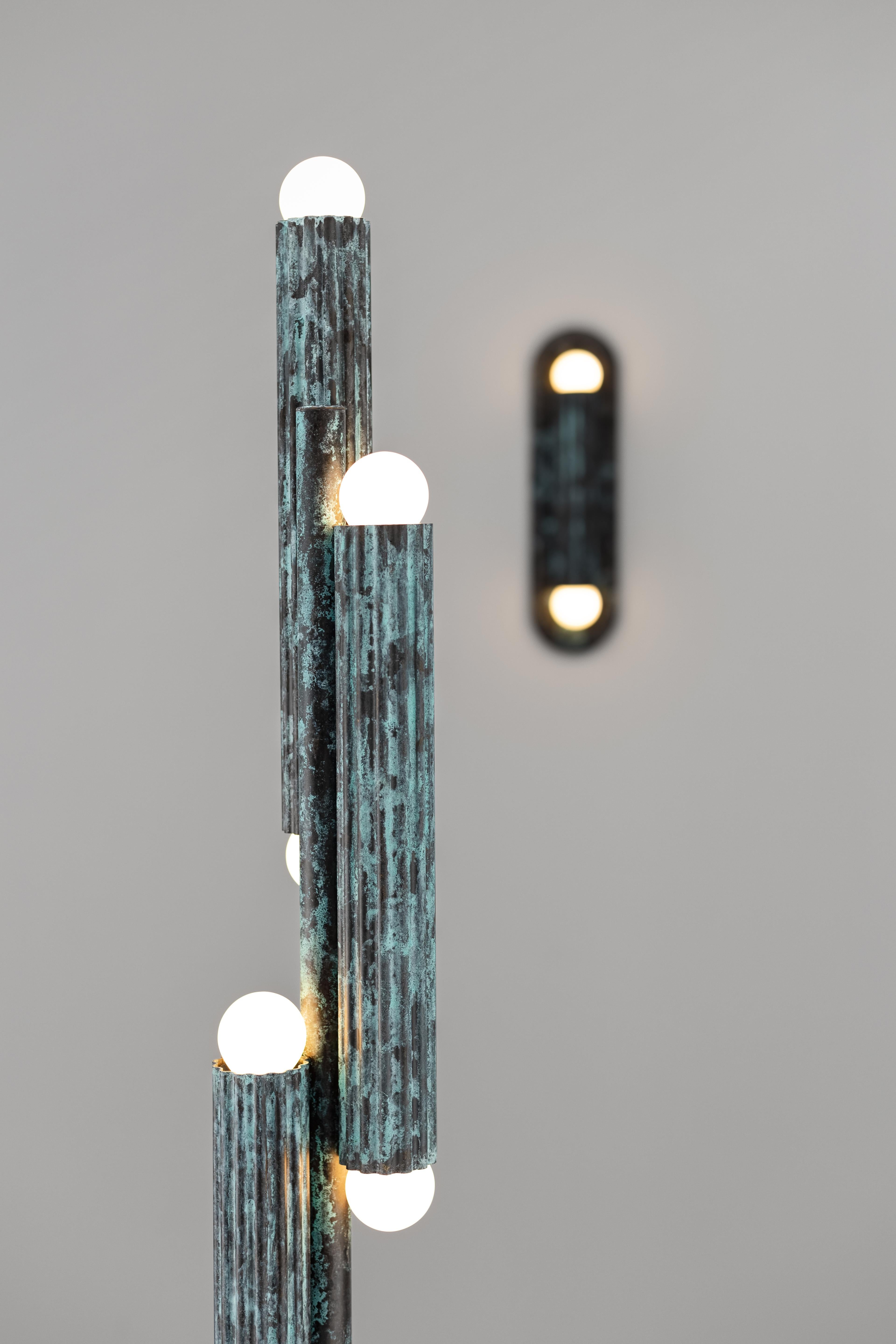 Thirty-two fluted solid brass cylinders are suspended in diamond formation, and a constellation hovering in space. From the side, vertical lines unfold in suspended harmony; from below, a celestial map of light emerges. Sculptural, commanding, and