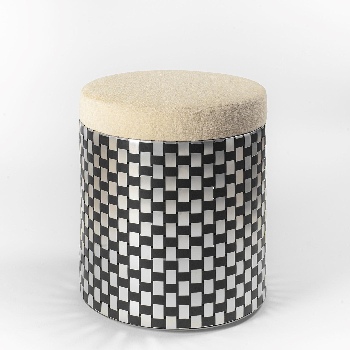 Inspired by the Optical Art movement of the 1960s, this splendid pouf flaunts a visually captivating and shimmering design fashioned by interweaving black and natural-finished aluminum slats recycled from industrial waste, a technique known as