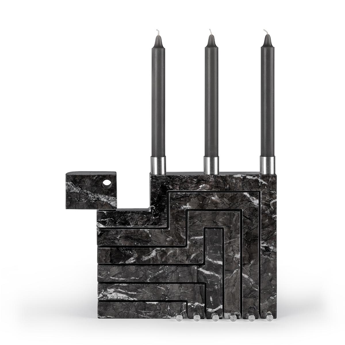 The Vestalia Black Marble Grigio Carnico and Chrome Details Candleholder is a unique and eye-catching sculptural piece.
When it is closed, the candelabrum appears like a monolithic marble slab. With just a few small touches, however, Vestalia opens