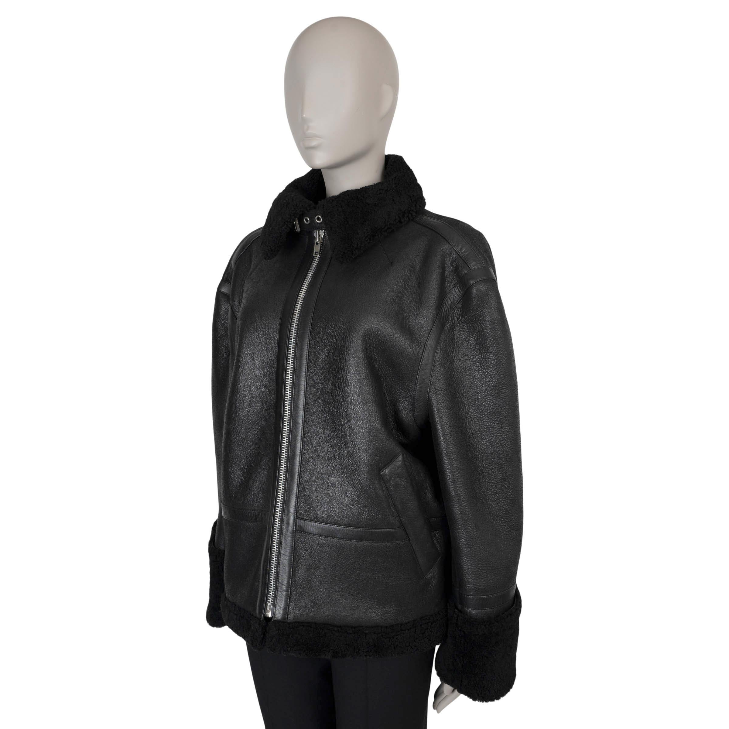 This 100% authentic Vetements biker jacket in black leather is a bold, statement-making piece. Fully lined in black shearling for warmth and luxury, it features an oversized fit with dropped shoulders and a high collar, complete with an adjustable
