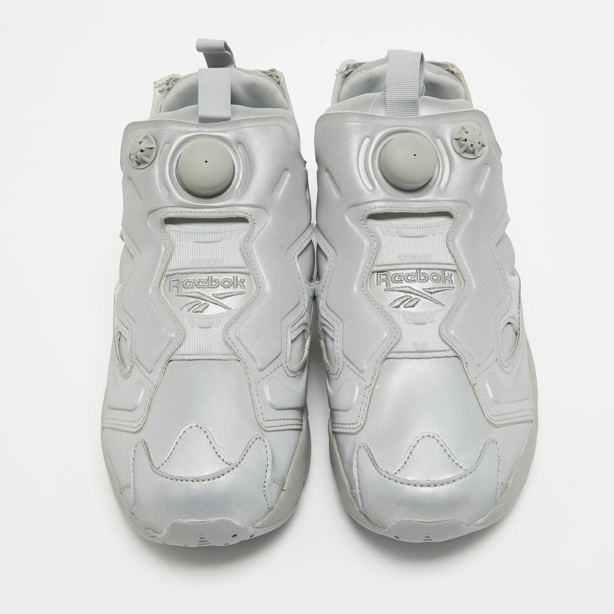 These chic sneakers are born from the Vetements x Reebok collaboration, taking into account both the brand's aesthetics. The grey reflective fabric construction takes the form of round toes and features the Reebok logo on the vamps as well as the