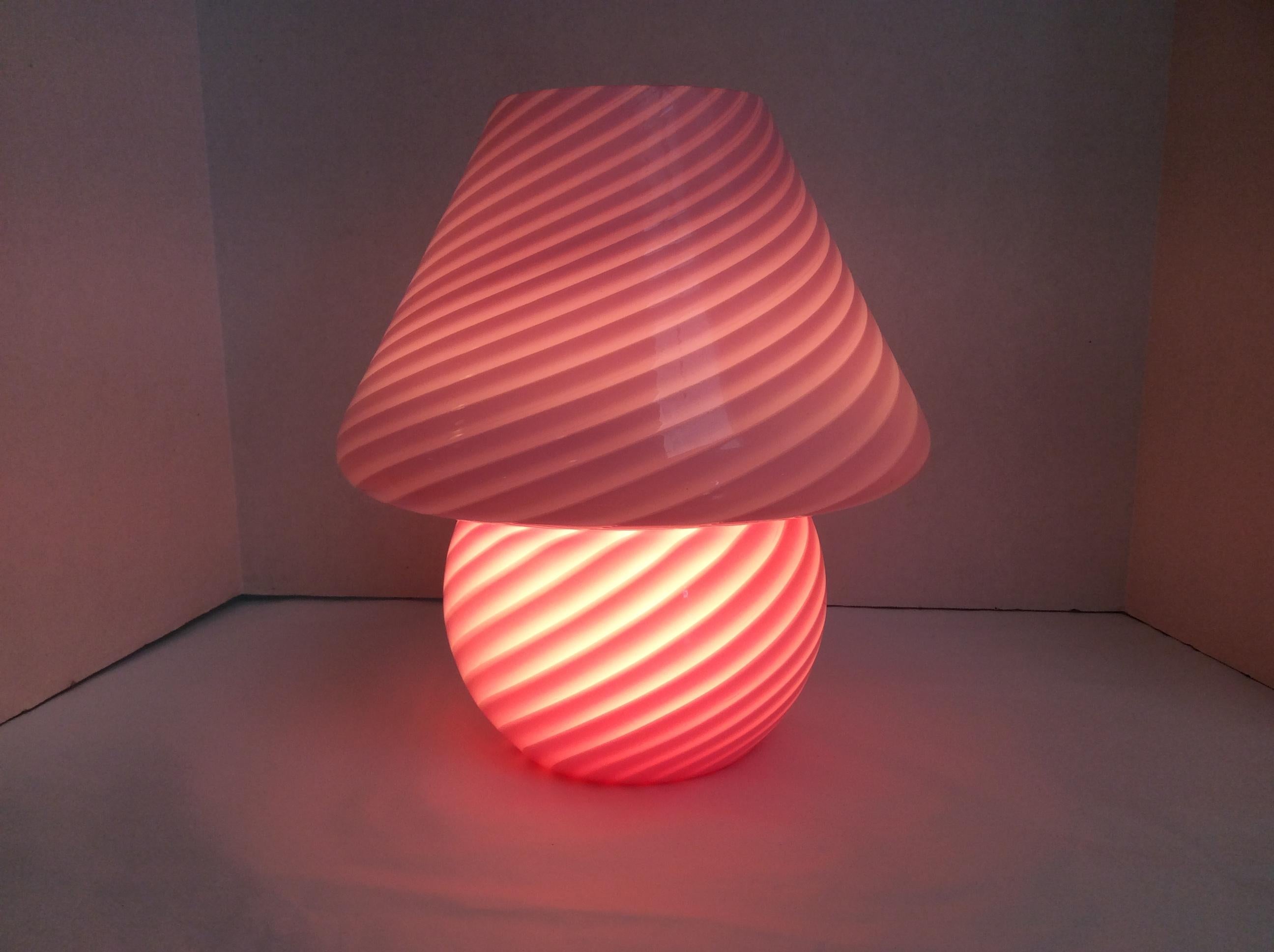 Italian Murano glass mushroom shaped table lamp. Pink Swirl design.
Vetri label on underside of shade,
Made in Italy, circa 1960s.
Measures: 10.5 inches high
4 inch opening at top of shade
9.5 inch wide at widest.

  