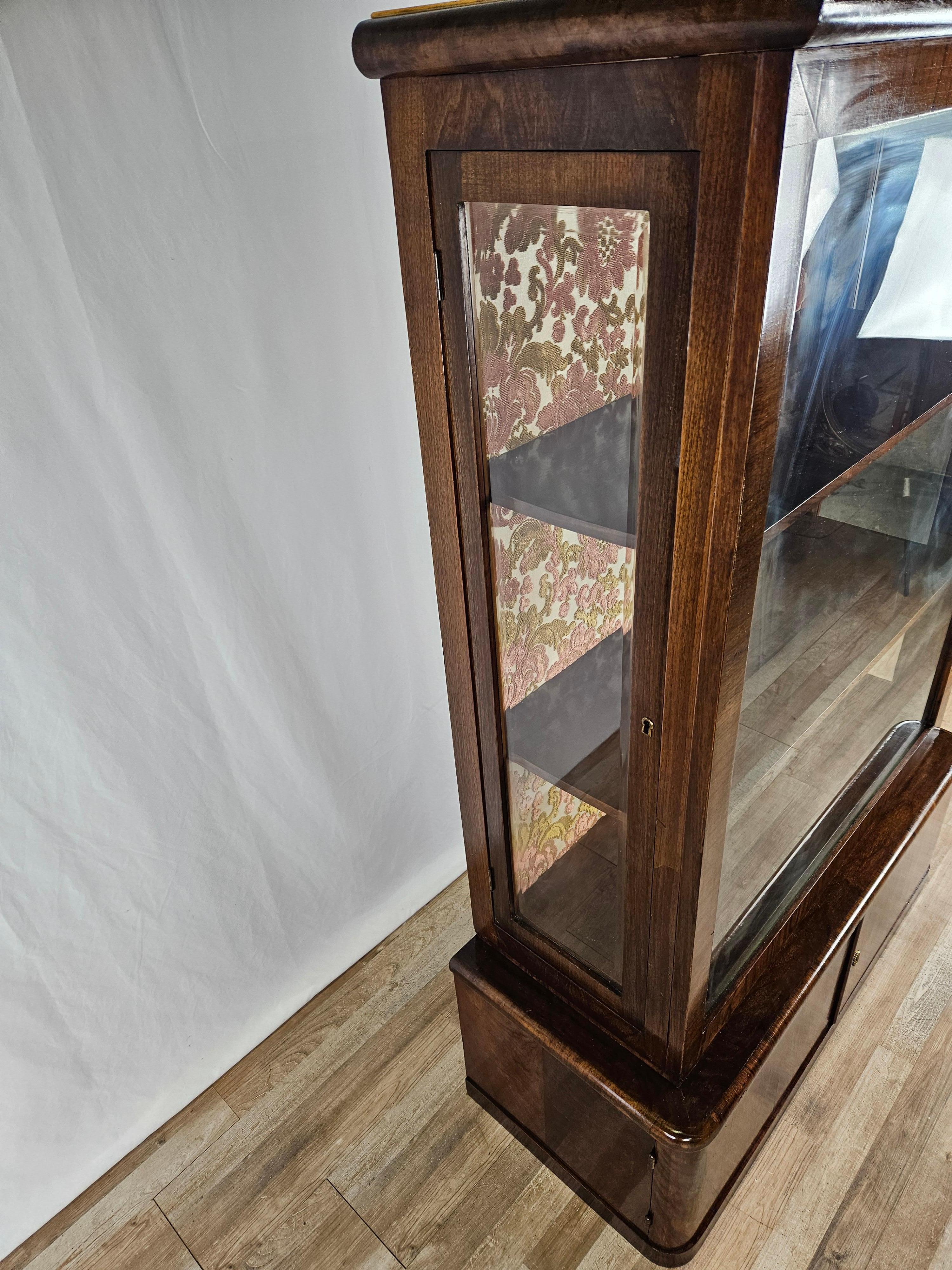 Art Deco display case in walnut burl from the early 1940s circa, double-body cabinet.

It has two side doors for opening the display case equipped with internal shelves and lined with a special fabric, and there is also a large and roomy compartment