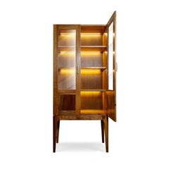 Contemporary display cabinet made of solid walnut with two glass doors and LED lighting