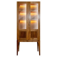 Contemporary display cabinet made of solid walnut with two glass doors and LED lighting