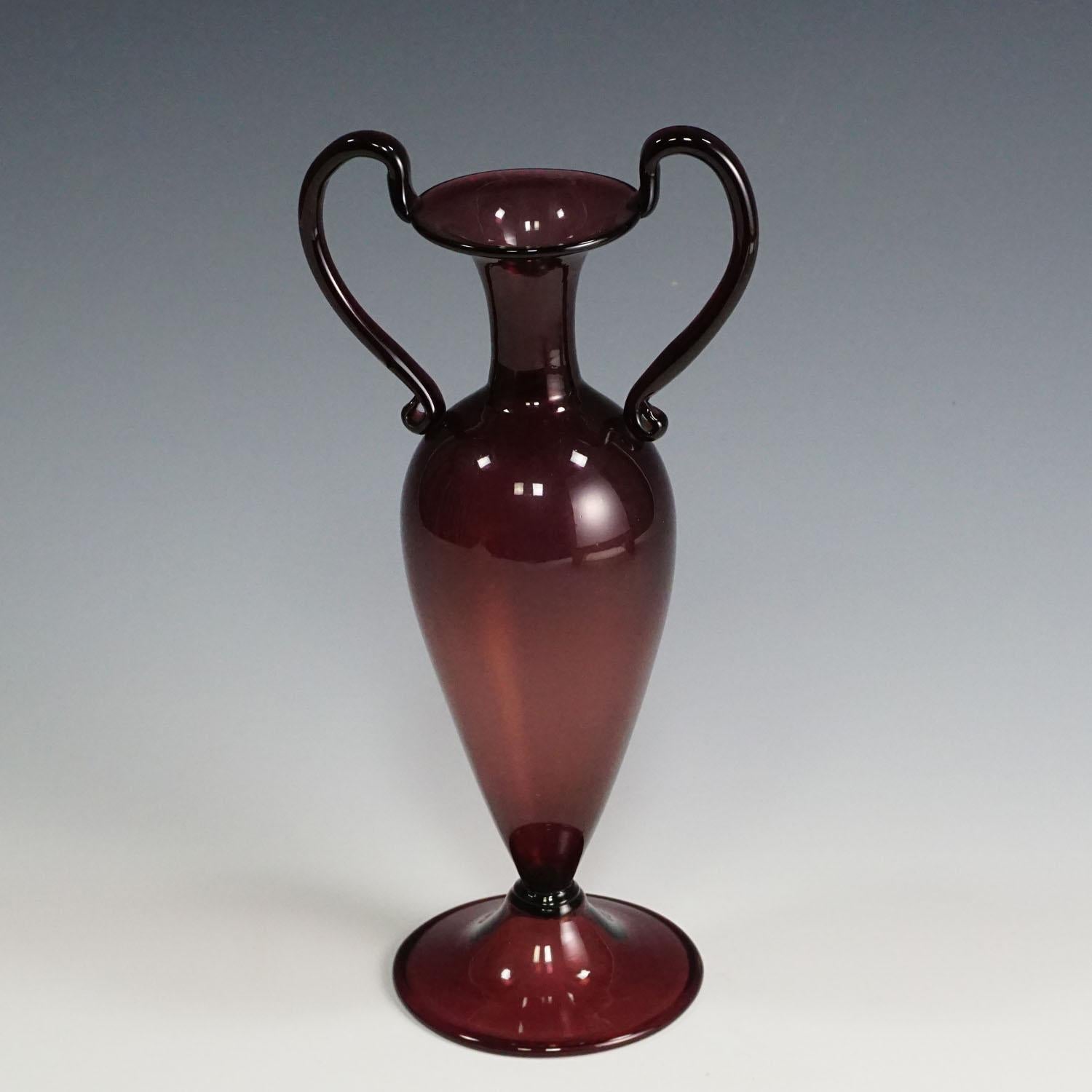 A 'Vetro Soffiato' glass vase in dark amethyst glass with two handles, Murano Venice ca. 1950.
Measures: Width 5.12