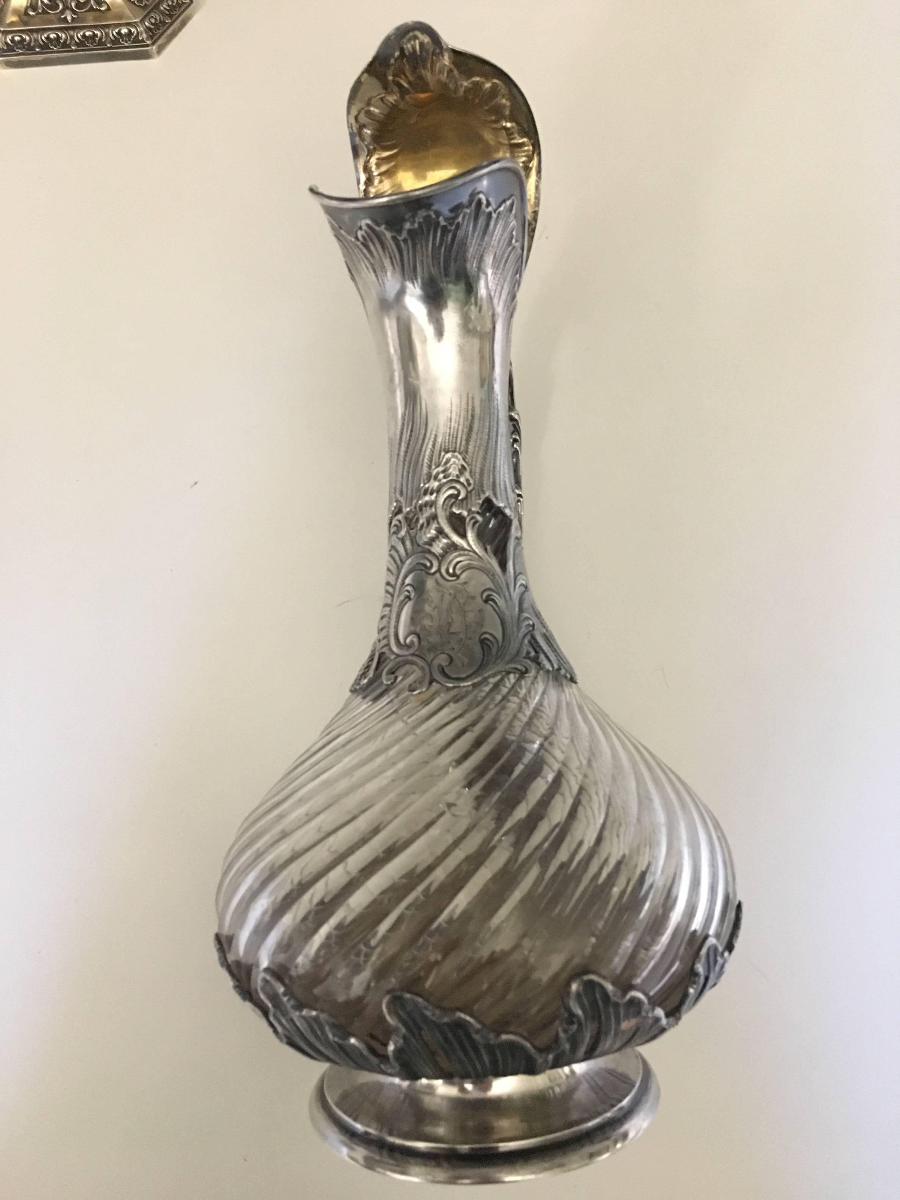 French sterling silver and cut-glass one claret jug.

Rococo styling spiral cut body.
Aiguiere in crystal with twisted ribs, the silver frame with rich decor of waves and foliage, the neck with cartridge Rocaille, the taking of the lid with
