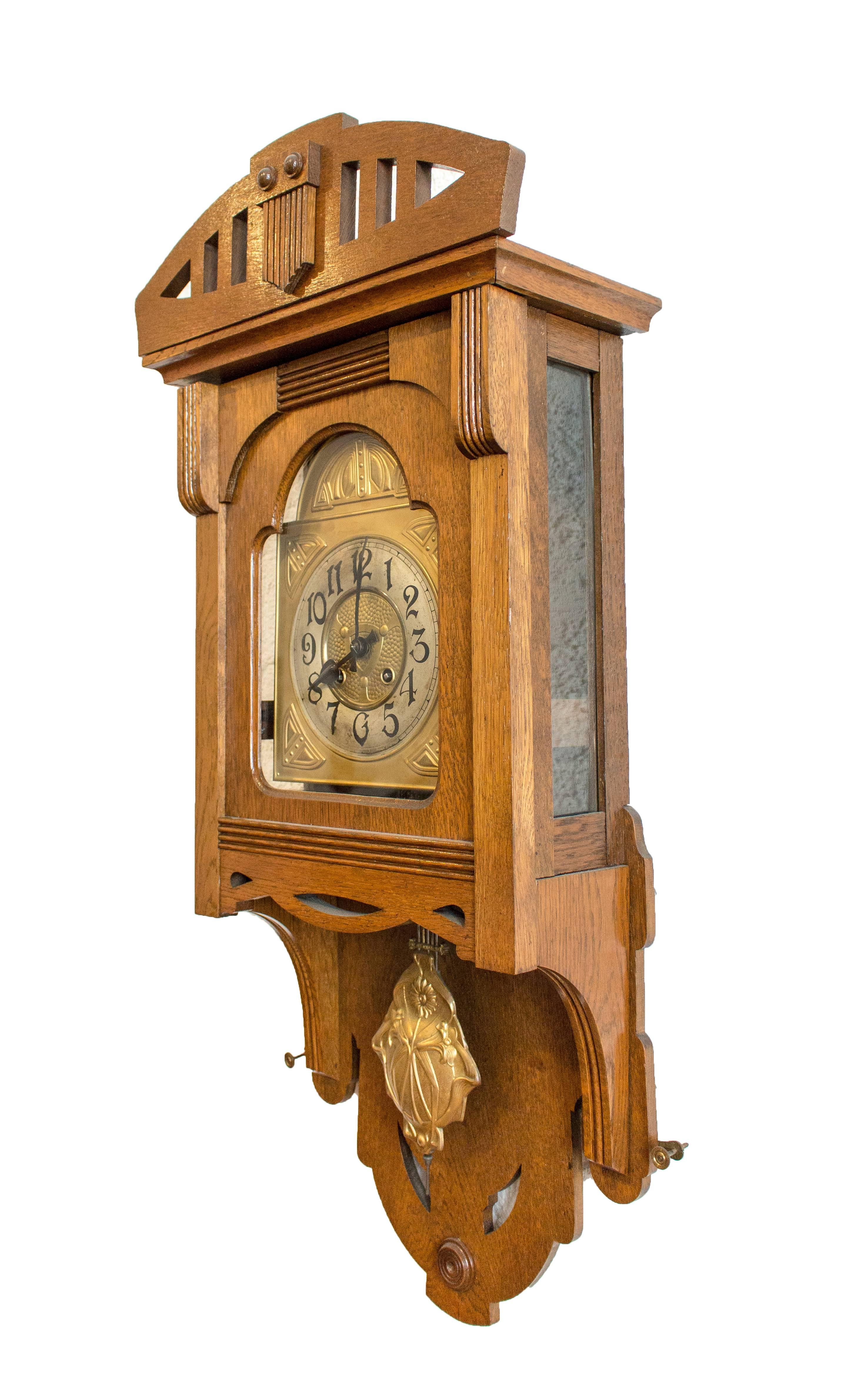 Schöne Jugendstil-Wanduhr aus der Zeit des Jugendstils:: um 1905. Das Uhrengehäuse ist aus Eichenholz:: das Pendel und das Zifferblatt sind aus Messing gefertigt. 
Die Uhr ist sehr gut restauriert und wurde von einem Uhrmachermeister überholt.