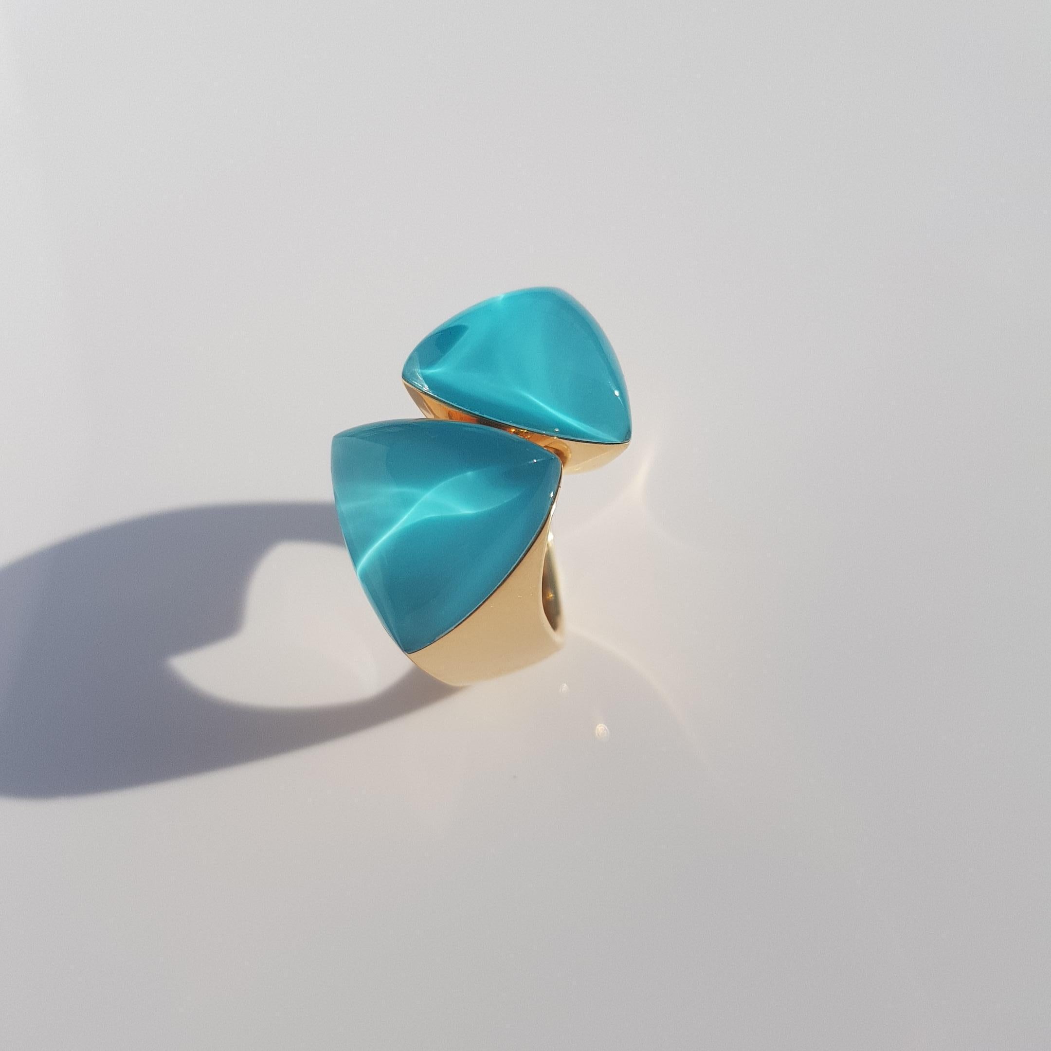 Vhernier Freccia ring, composed out of a wide band in 18KT rose gold, adorned in the centre with a plate of turquoise and a cabochon rock crystal. The stunning blue of the turquoise adds a pop of colour and is given some sparkle by the magnificent