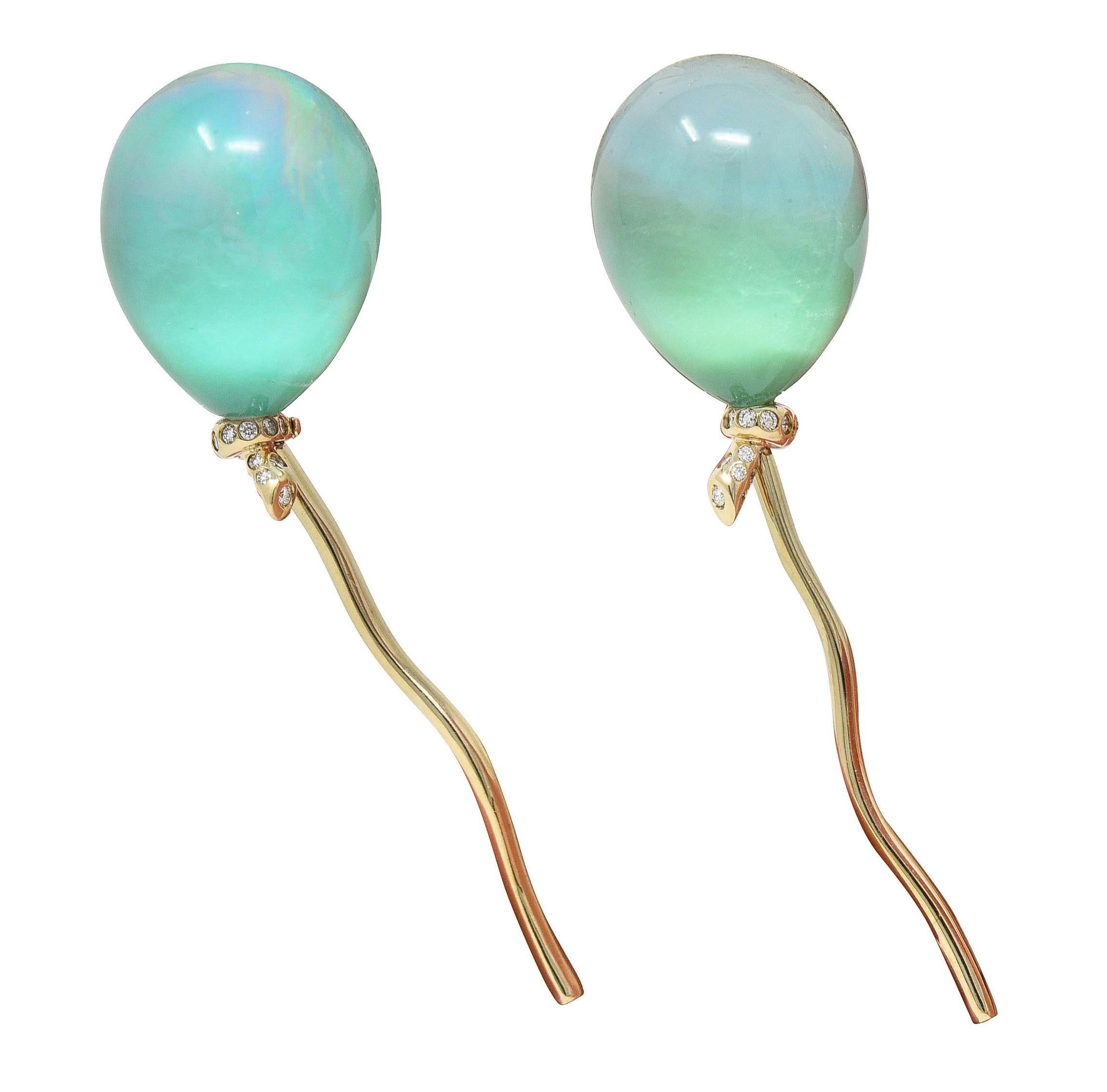 Designed as stylized balloons terminating with articulating gold ribbon tails
Featuring pear-shaped crystal quartz cabochons measuring 20.0 x 16.0 mm 
Transparent and colorless - backed by layered chrysoprase and abalone 
Displaying an iridescent