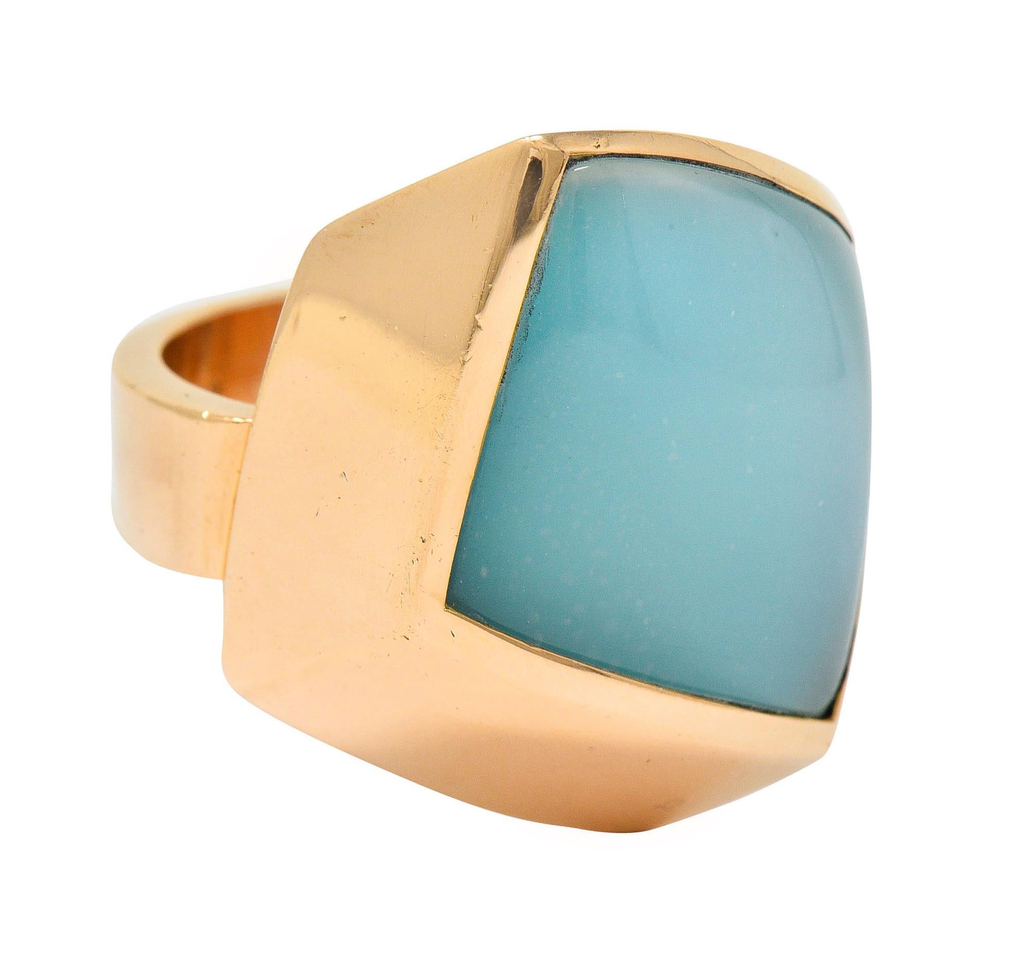 Gemstone ring is designed as a slanted and curved parallelogram form

Centering a doublet of rock crystal quartz topping a tablet turquoise

Gemstone has very good polish and exhibits moderately strong adularescence

Bezel set in a polished rose