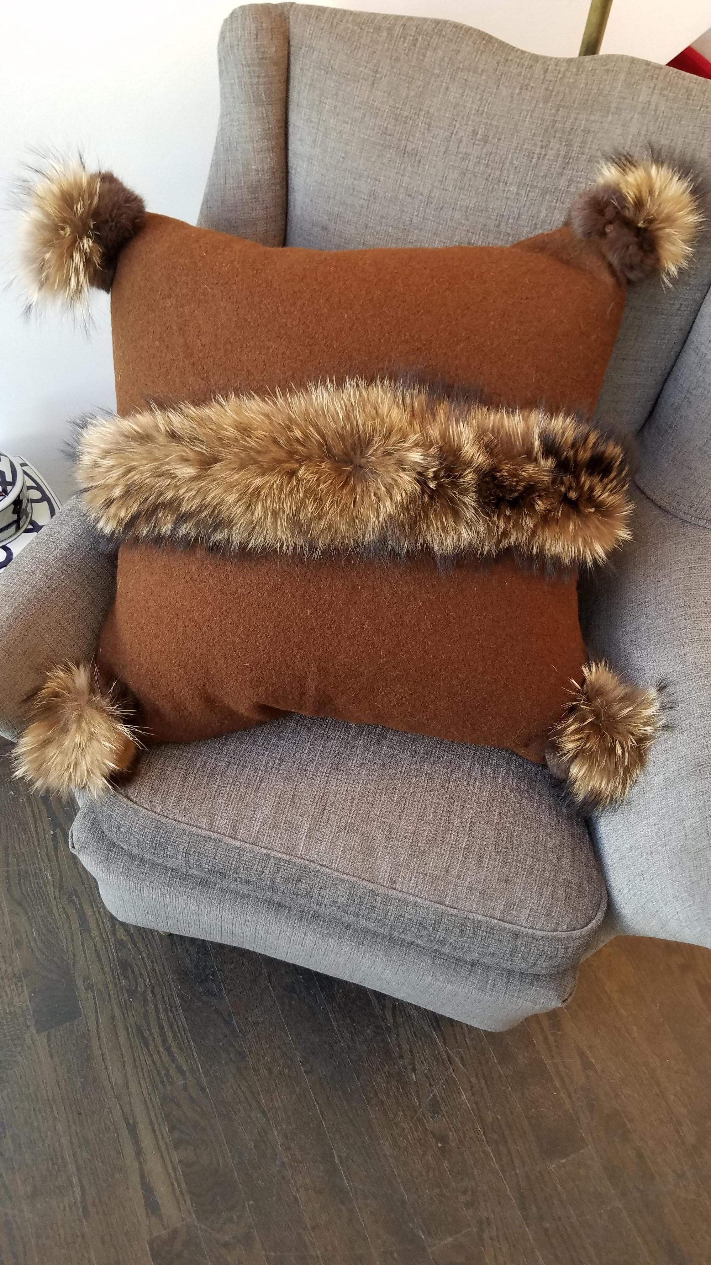 Sophisticated handcrafted pillow with a rich tan Merino wool background accentuated with fur trim. Comes with feather/down insert and concealed zipper. Made in Italy.
