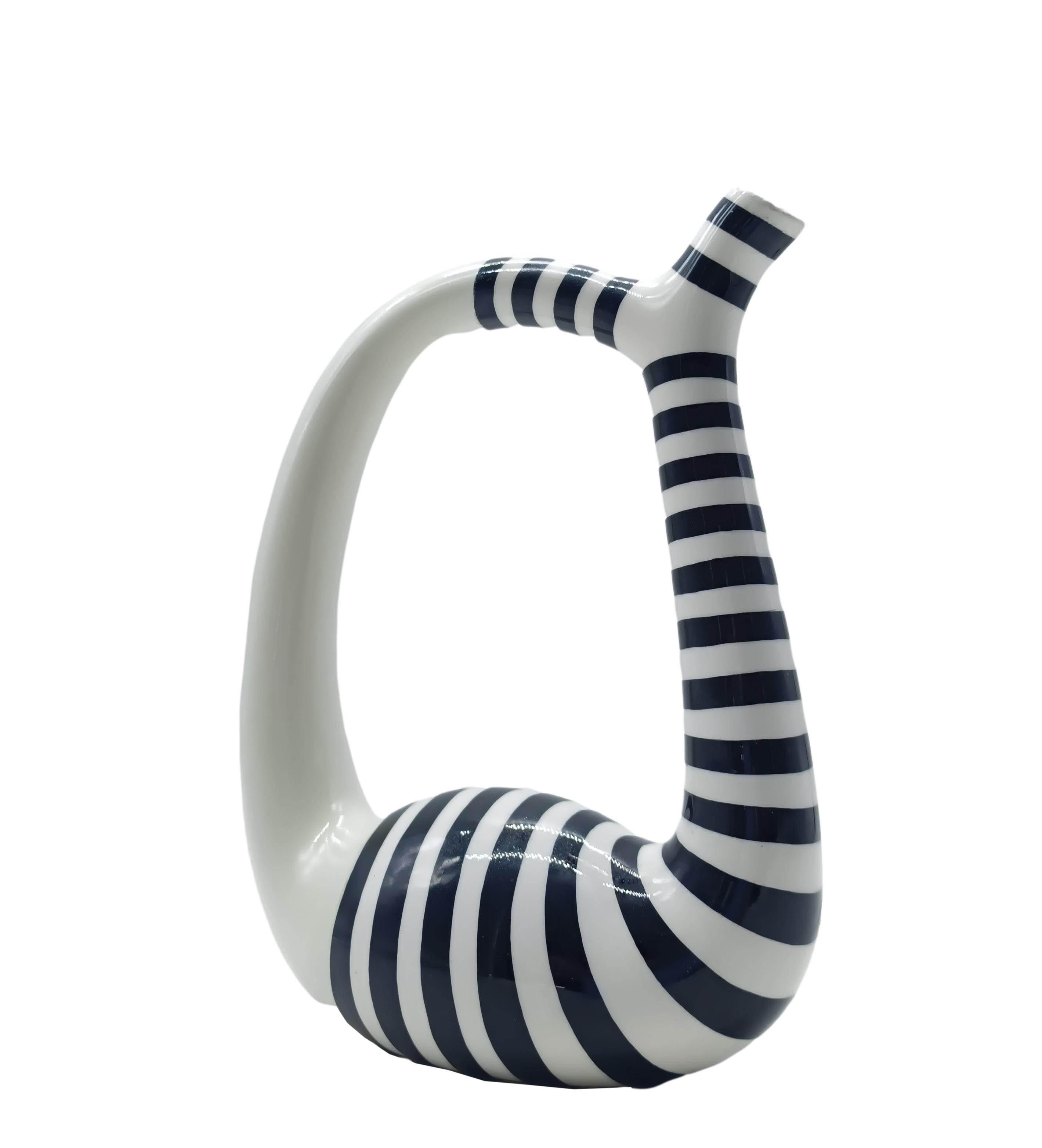 Elegante bottiglia in ceramica smaltata realizzata a mano, caratterizzata da una forma sinuosa e moderna. Decorata con un motivo a righe bianche e nere, questa bottiglia è perfetta per aggiungere un tocco di stile unico a qualsiasi ambiente. Ideale