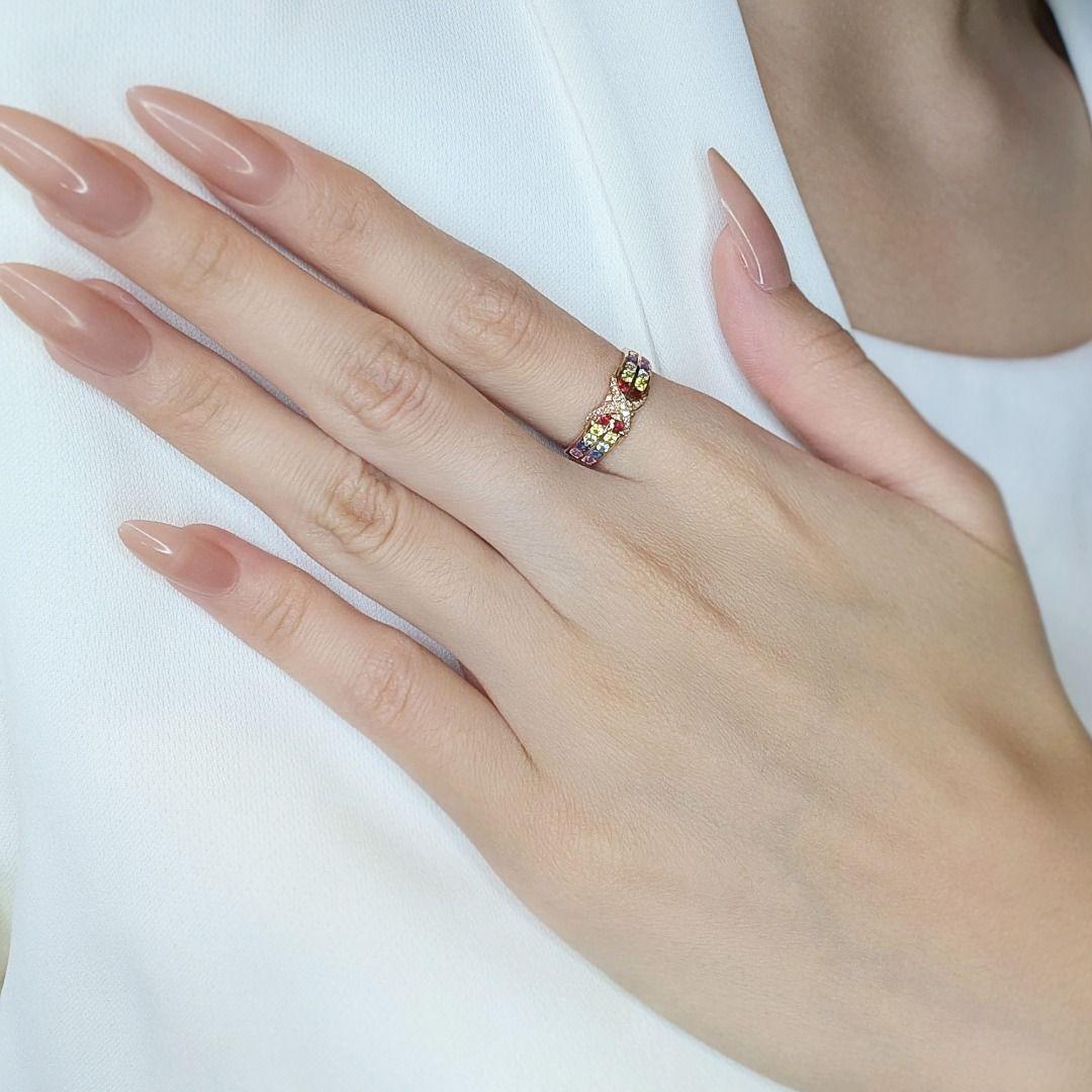 This delightful ring captures the essence of color and elegance with its unique and lively design. Set in radiant 18K rose gold, the warm tones of the band complement the vibrant hues of the 8 round brilliant sapphires, showcasing shades of pink,