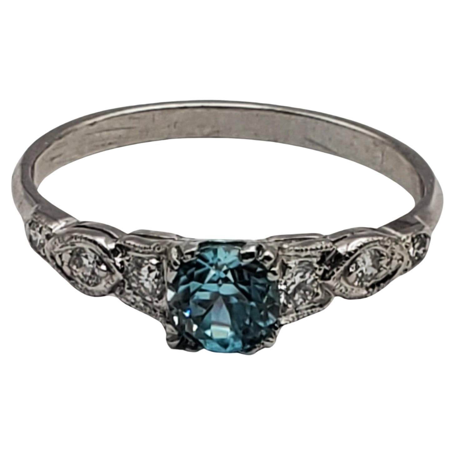 Beautiful and unusual blue zircon and diamond ring. The ring features a 0.73ct round blue zircon that is eye clean and vibrant in color. The mounting contains six round brilliant cut diamonds with a total weight of 0.10cts. The cathedral design has