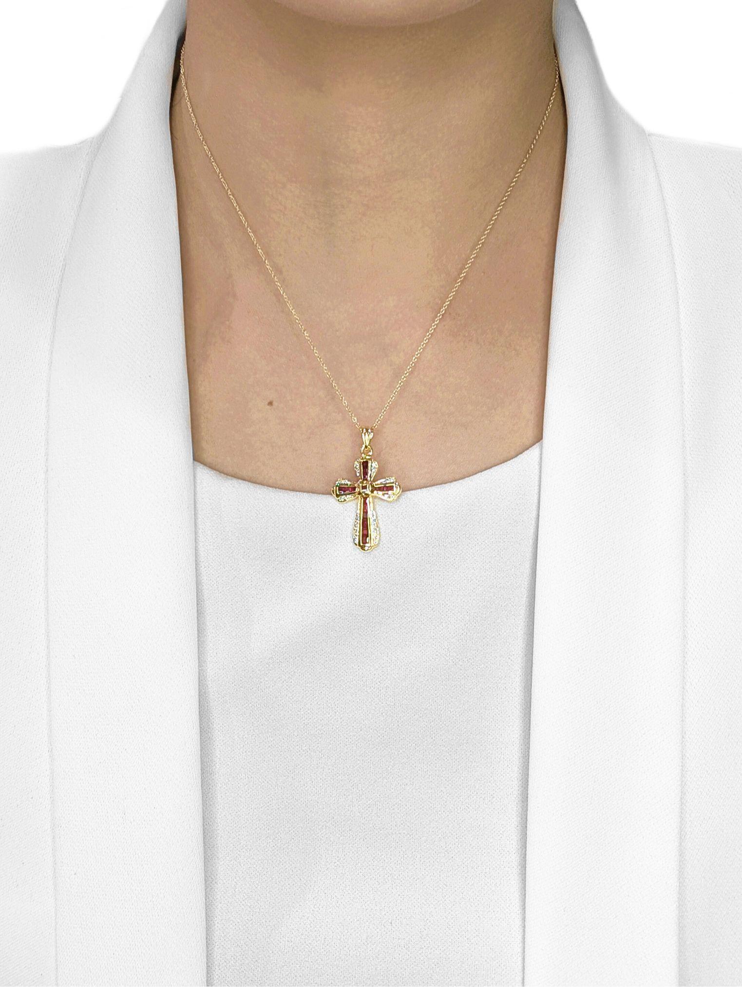 Réalisé en or jaune 18 carats, ce pendentif présente une croix audacieuse et élégante sertie de 16 rubis taille princesse d'une valeur totale de 0,65 carat. Leur teinte rouge vif est magnifiquement contrastée par 20 diamants naturels ronds et