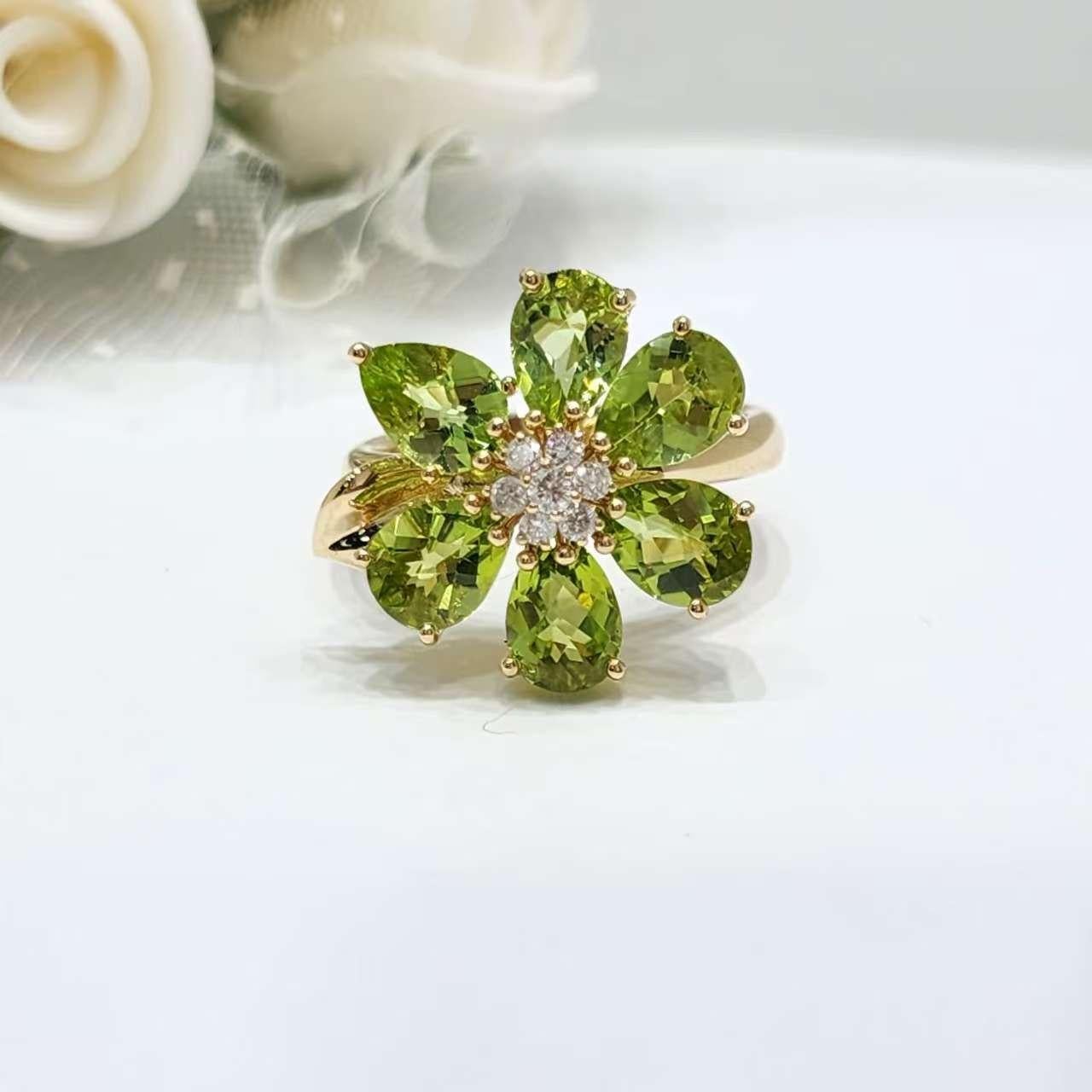 4.6 CT - Péridot,
0,15 CT - Diamants

Transformez votre collection de bijoux avec cette radieuse bague à fleur de péridot en or jaune 14 carats. Avec six péridots brillants en forme de poire totalisant 4,6 carats, leur éclat vert luxuriant capture