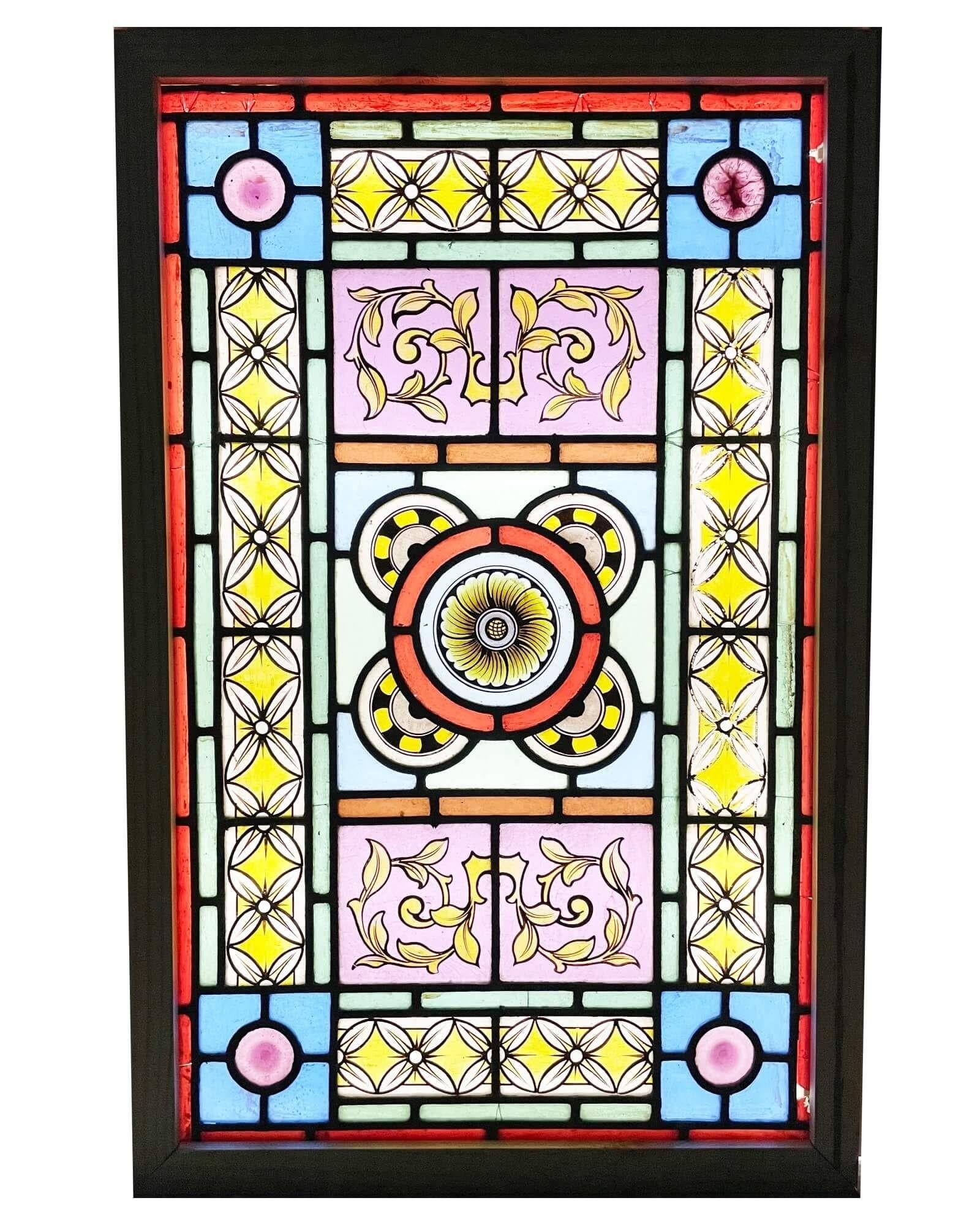 A vibrant antique artisan stained glass window with floral patterns. This beautifully vibrant window dates from the late 19th century, but its intrinsic eye-catching design would make a spectacular focal point in properties old and new. Its centre