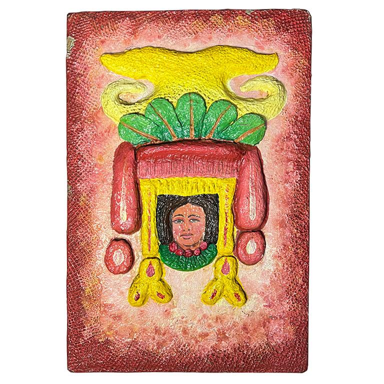 Cette plaque murale vintage est un bel exemple de l'art populaire mexicain traditionnel. Avec sa surface texturée, le motif présente une figure féminine peinte à la main, encadrée par des accents jaunes, verts et rouges vifs. Le charme rustique et