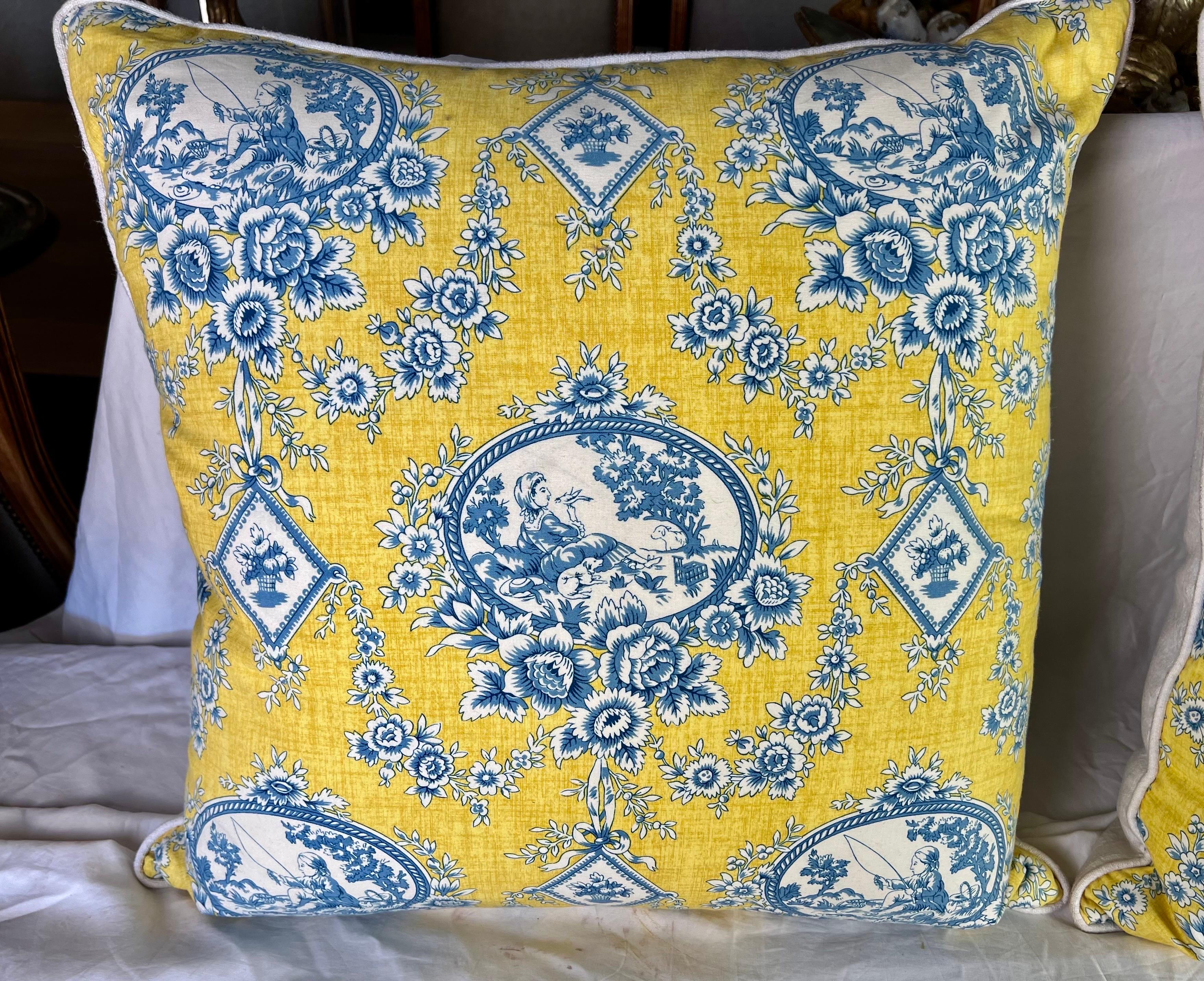 Diese Kissen aus dem 20. Jahrhundert haben ein Toile von Brunschwig & Fils in leuchtenden Gelb- und Blautönen. Sie zeigen geometrische Muster, Rauten mit Blumenbouquets und bezaubernde Szenen von Kindern beim Fischen und beim Entspannen in