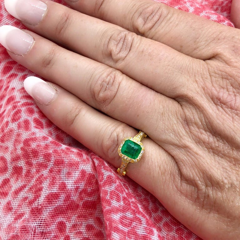 The perfect vivid green emerald color! The 18k gold ring features a Colombian emerald-cut 1.35-cts. emerald, with a delicately designed mount set with 104 round brilliant-cut diamonds totaling 0.45 carat. The ring weighs 3.6 grams and is currently