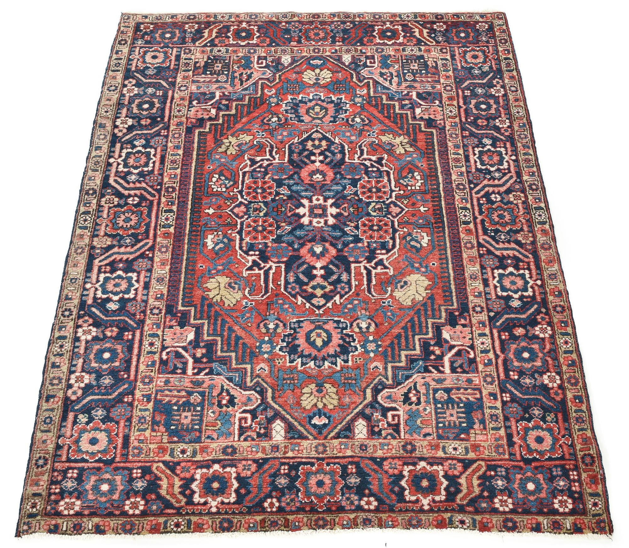 Semi-antique Heriz rug handwoven with wool in an elegant artistic design filled with flowers and traditional Persian symbols. The bold colors and central medallion are very typical of a Heriz rug. Size: 4'8 x 6'5.