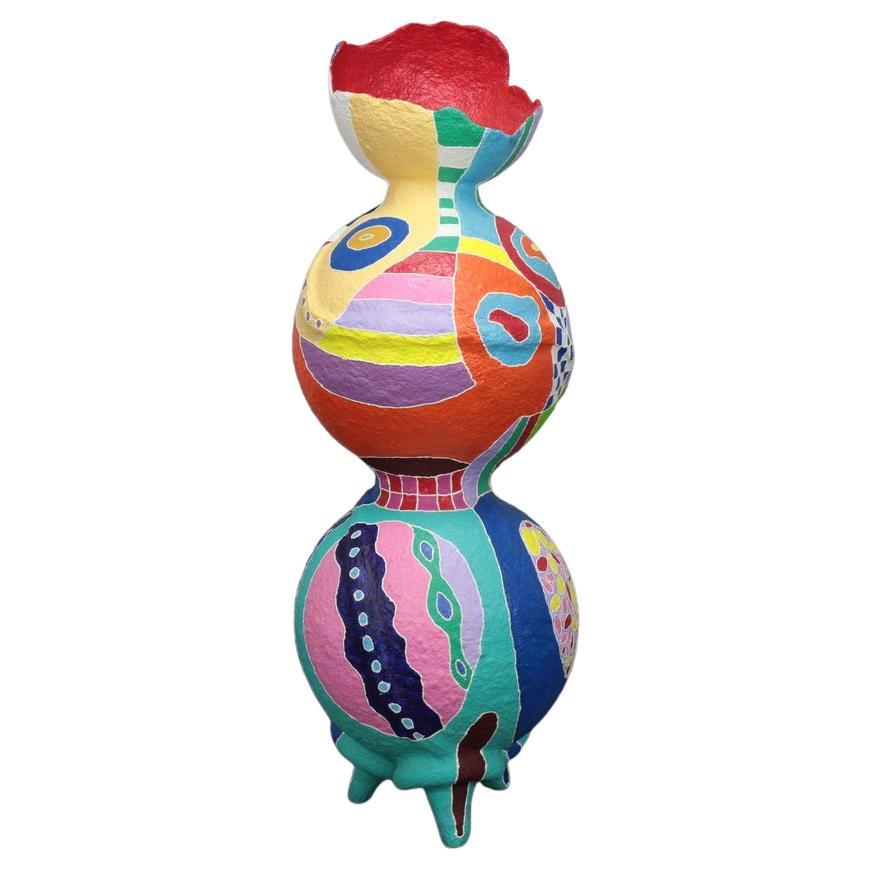 Vibrant Contemporary Standing Sculpture in Papier-Mâché, in the style of Niki de Saint Phalle
This striking papier-mâché sculpture radiates joy and energy through its bold palette of bright reds, greens, blues, and yellows. The playful, totemic form