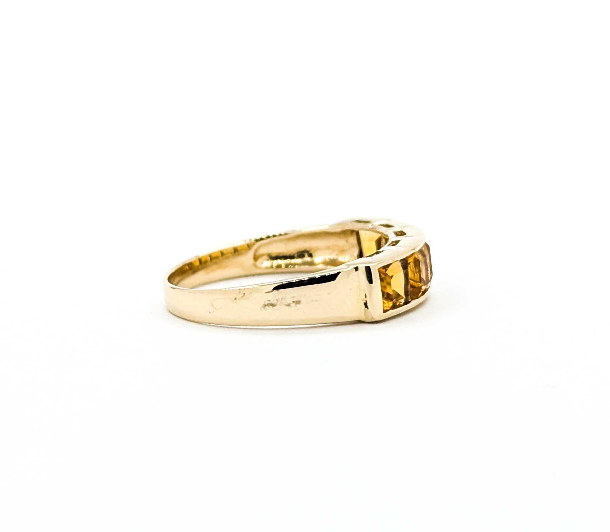 This vintage band features five square-cut citrine gemstones, weighing approximately 1.00 carat total. The stones are channel-set in a row across the top, their warm golden-orange tones creating a vibrant and cheerful look. The sleek, low-profile