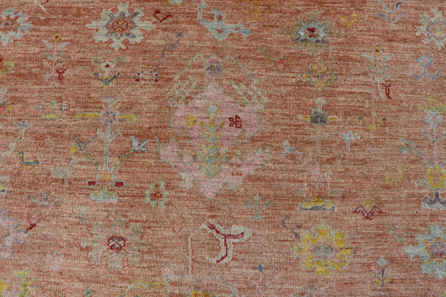 Vibrant Floral Medley on Salmon Pink Hand-Knotted Rug by Keivan Woven Arts. rug / AN-149682, Turkish 21st Century.
Measures: 10'0 x 12'11 
The rug showcase's a beautifully woven rug with a vibrant and colorful design on a warm salmon pink
