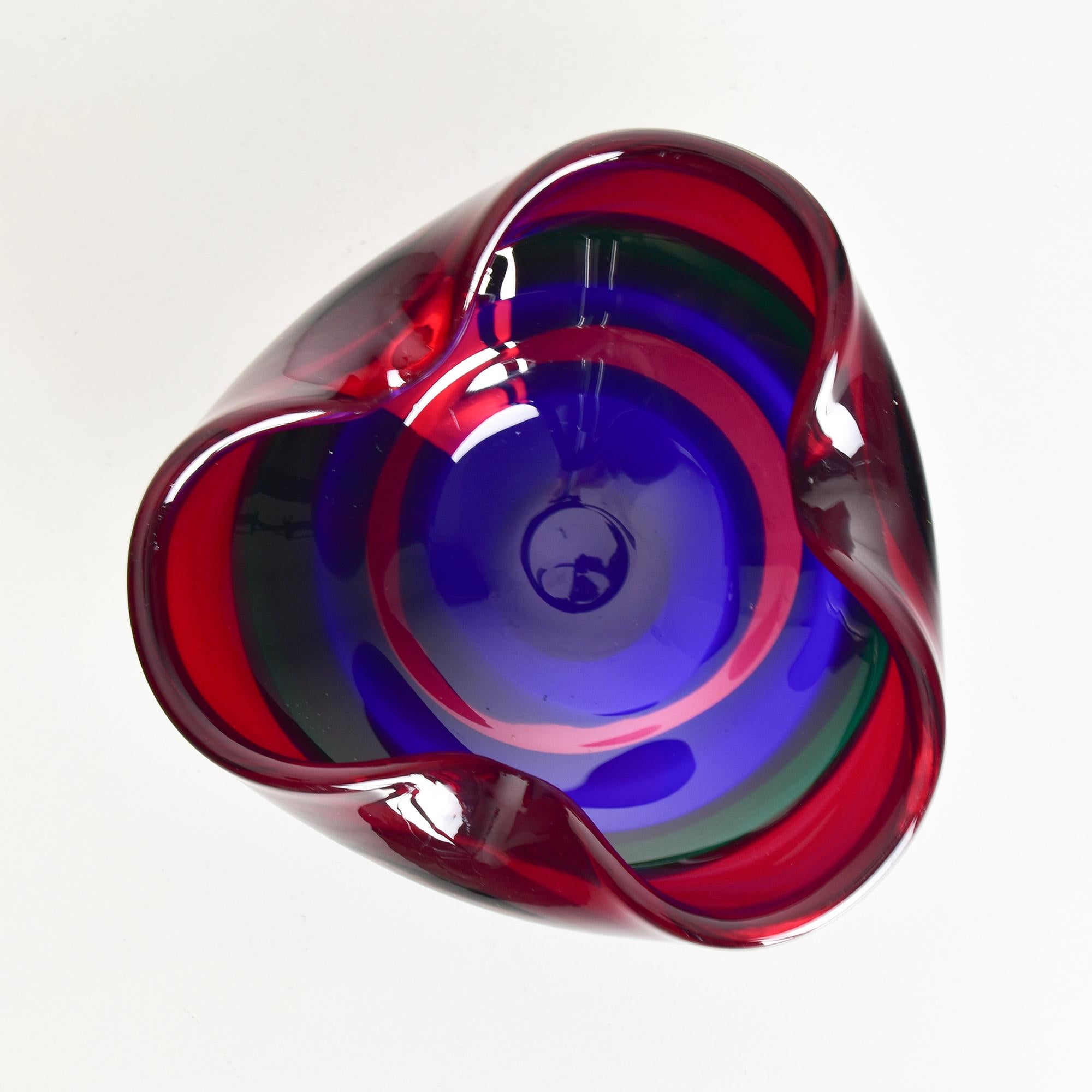 Ce magnifique bol en verre, conçu par Fulvio Bianconi pour Mazzega, présente l'utilisation vive des couleurs et des formes organiques typiques du travail de Bianconi. Renommé pour ses contributions artistiques à la conception du verre au XXe siècle,