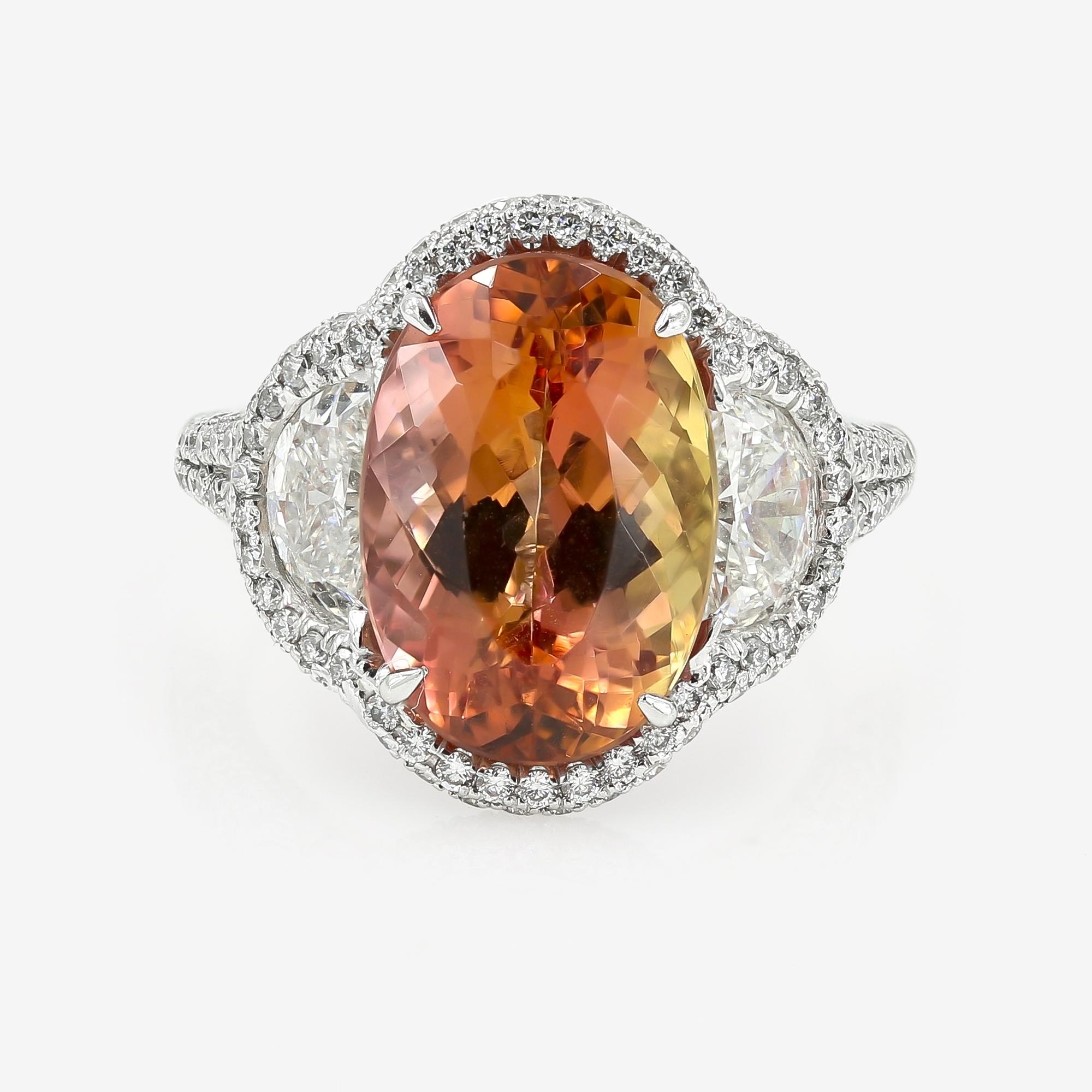 This vibrant rich colored 7.56cts. oval cut Imperial Topaz is set in platinum with 2 half-moon cut diamonds = 1.15cts. t.w. on the sides which are each set in a semi-halo setting. In addition, there are 227 round cut diamonds = 1.35cts. t.w. around