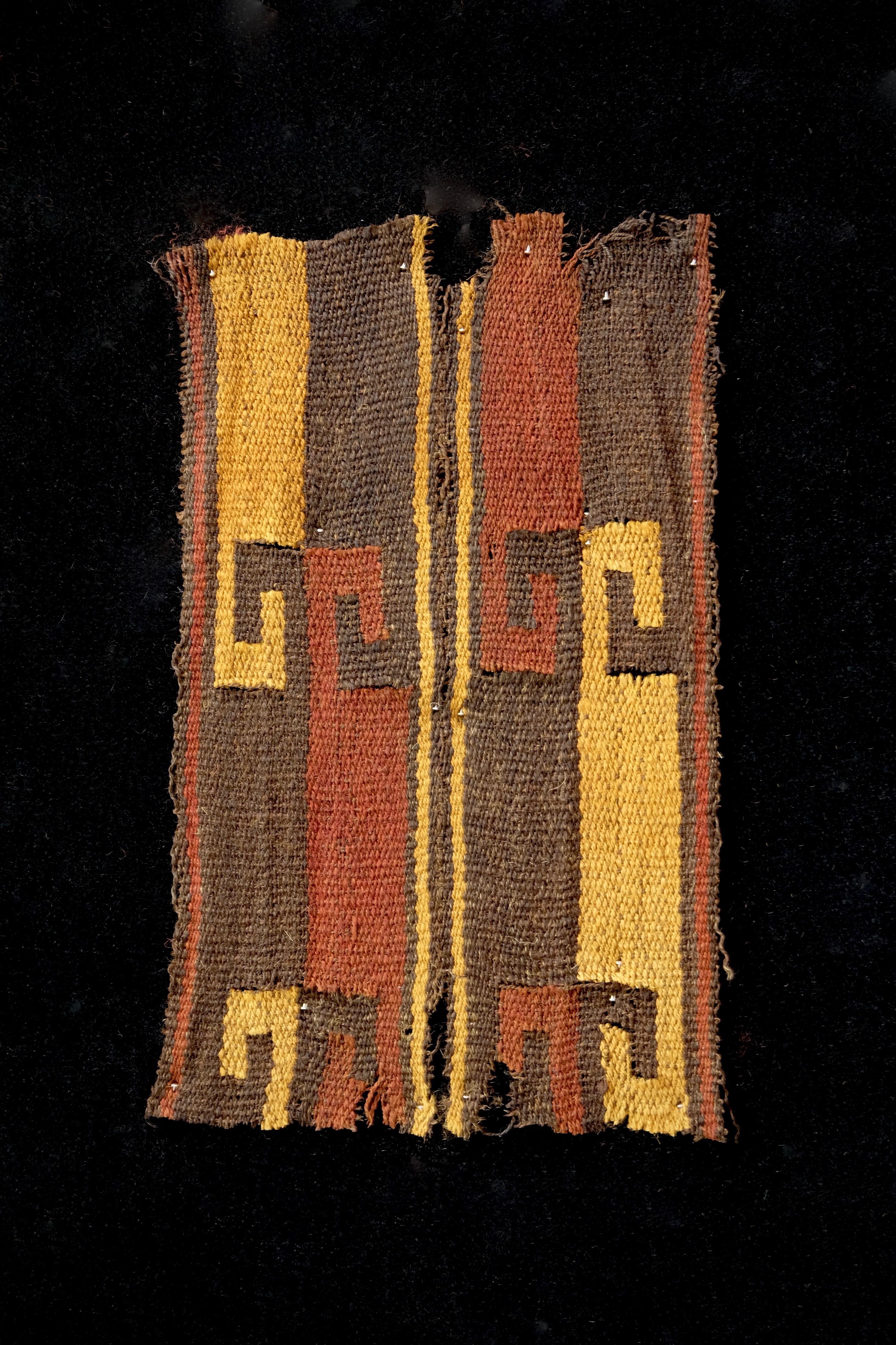 Brown, yellow and red wave like pattern textile fragment. Framed in a black shadowbox.

It is a wonder to behold antiquities such as a Pre-Columbian textiles, an authentic piece of art that has been preserved for centuries and that survives
