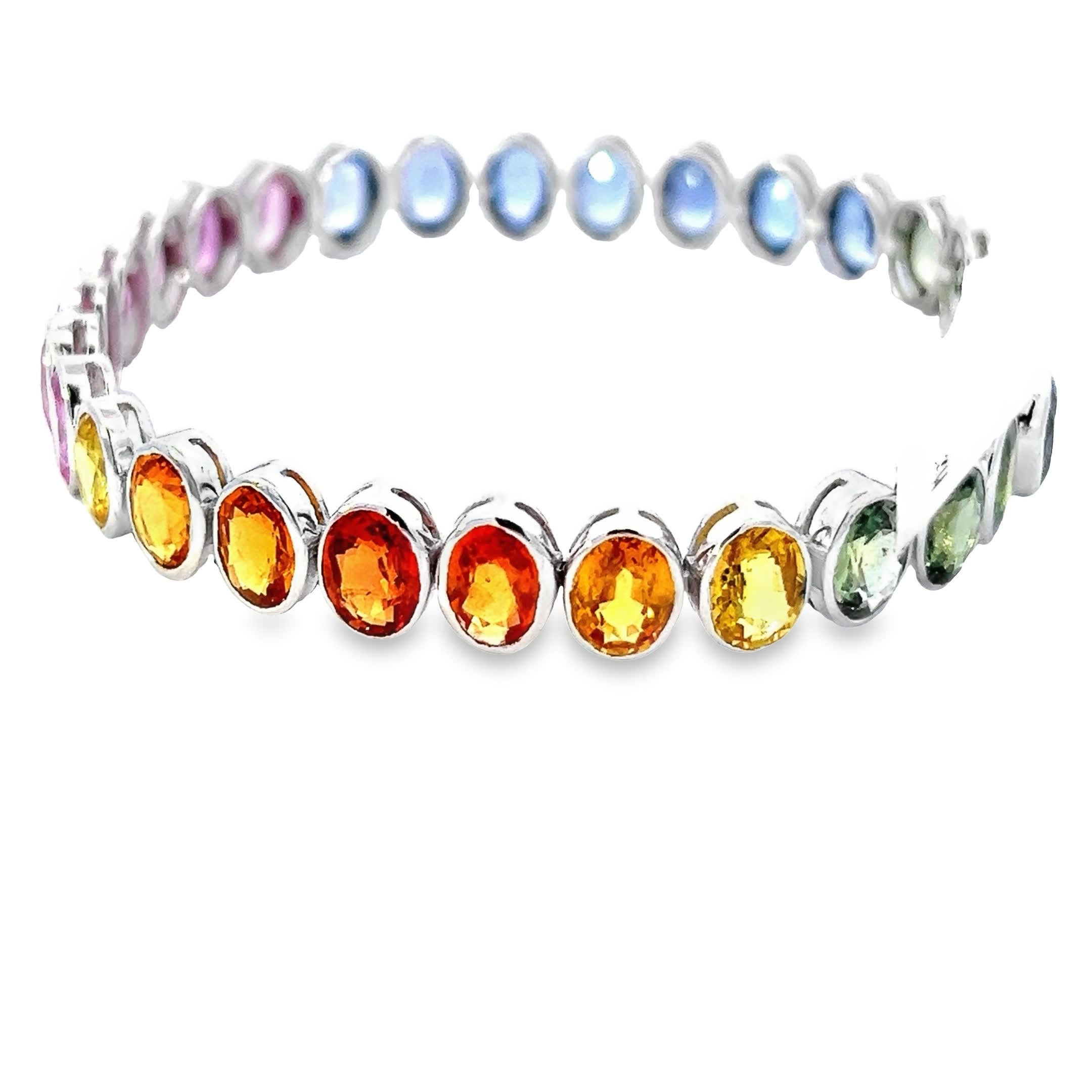 Dieses atemberaubende Armband zeigt eine schillernde Reihe mehrfarbiger Edelsteine, von denen jeder sorgfältig in einen eleganten Silberrahmen gefasst ist. Die leuchtenden Farbtöne reichen von tiefem Blau und sattem Grün bis hin zu auffälligem Pink