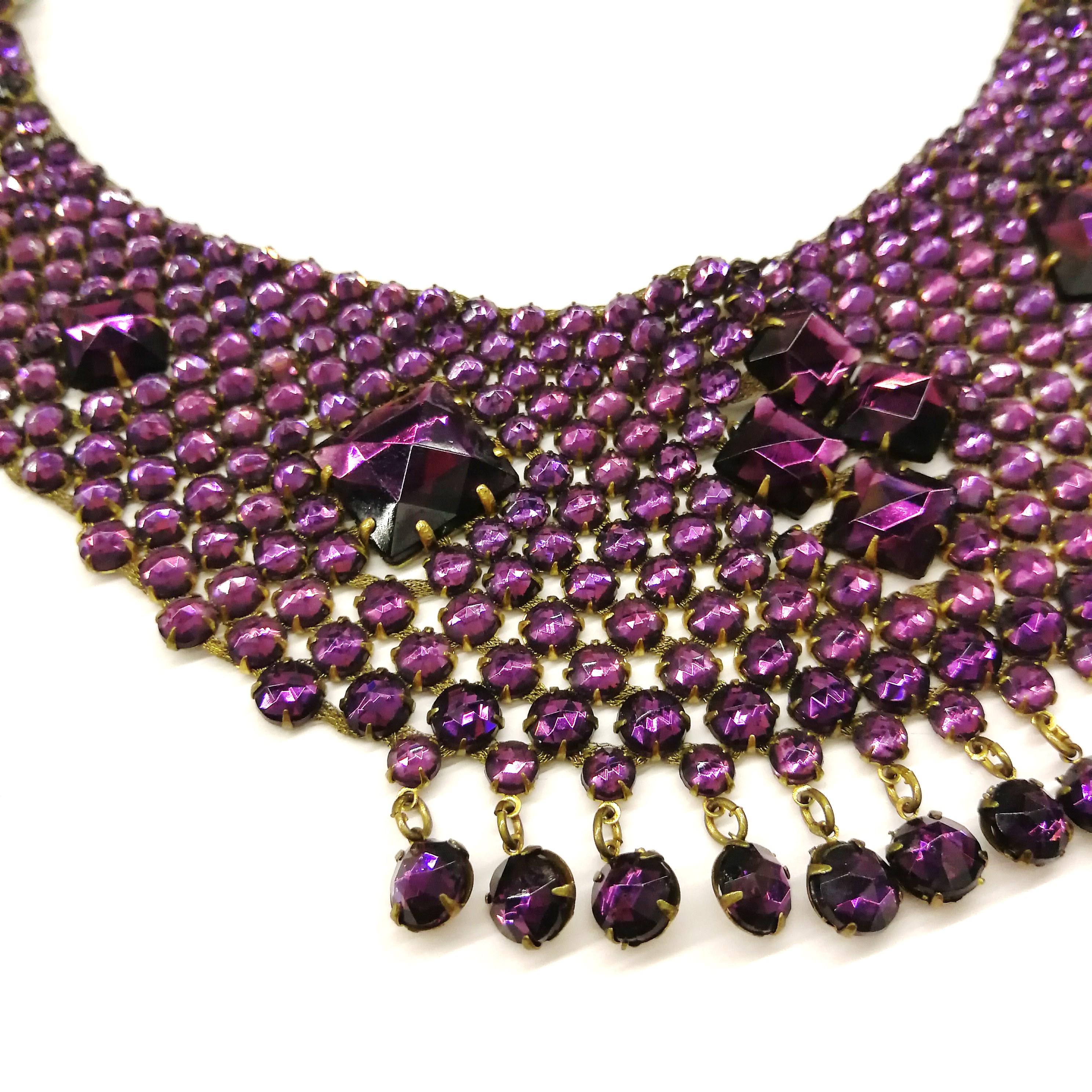 A very rare and wonderful necklace, set in a soft gilt metal, with amethyst glass faceted cabuchons set all over, interspersed with square cut large cabuchons, placed at intervals throughout, and a small fringe of claw set cabuchons along the bottom