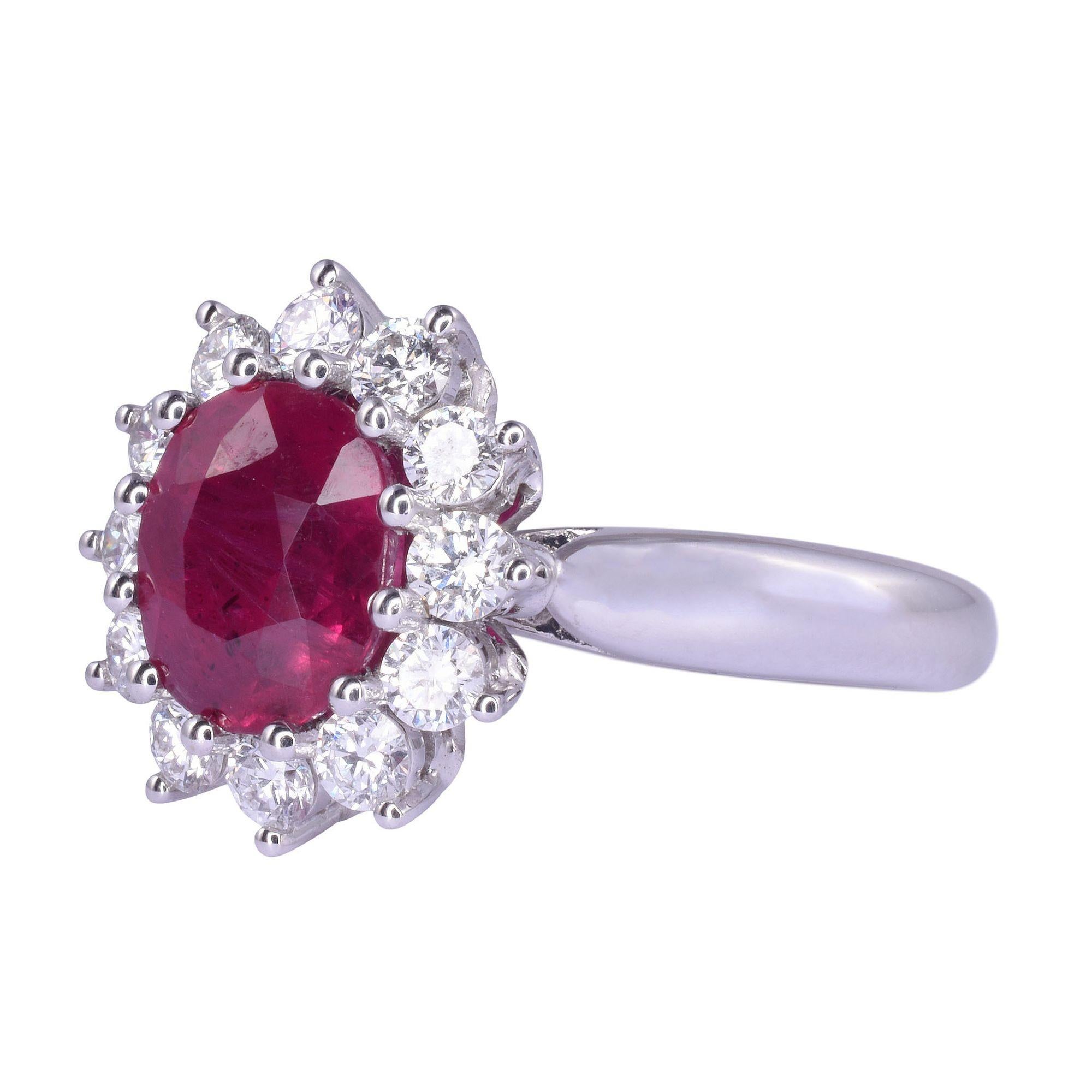 Estate vibrant ruby & diamond 18KW ring. This 18 karat white gold ring features an oval ruby at 1.98 carats. The ruby is very slightly purplish red with strong saturation and has been heat treated, as are most rubies. It is accented with 12 round