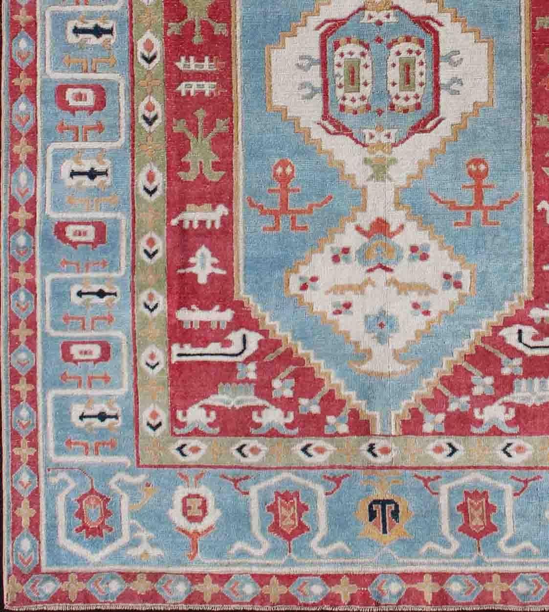 Red, aqua blue, geometric design Oushak rug from Turkey, rug en-179685, country of origin / type: Turkey / Oushak, circa 1950

This vintage Turkish Oushak rug presents a unique and vibrant composition. An array of diamond motifs fills the center