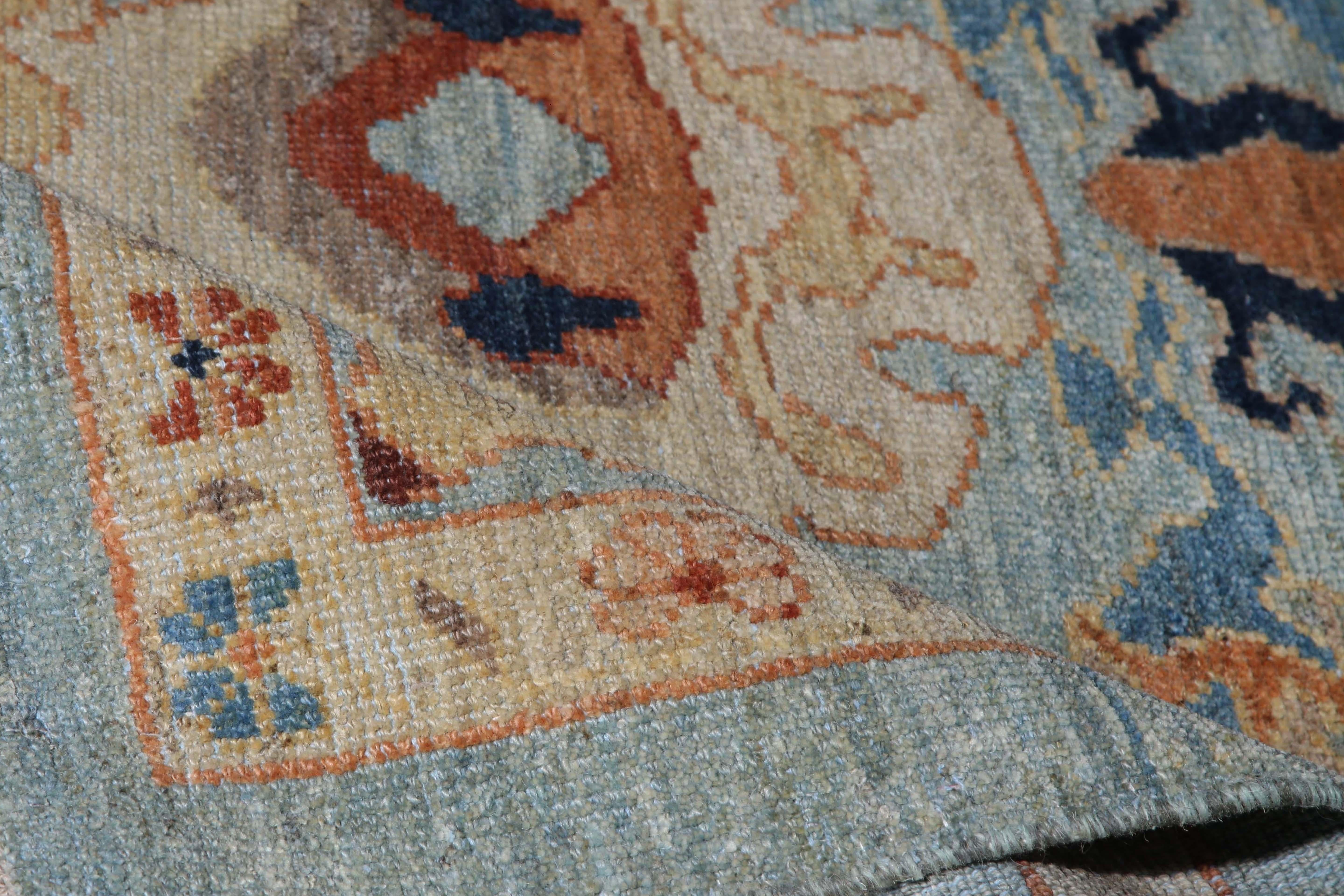 Introducing our exquisite handmade Turkish Sultanabad runner rug, measuring 3'6'' by 14'6''. This stunning rug features a light blue background that provides the perfect canvas for the vivid pops of color in its traditional design. The eye-catching