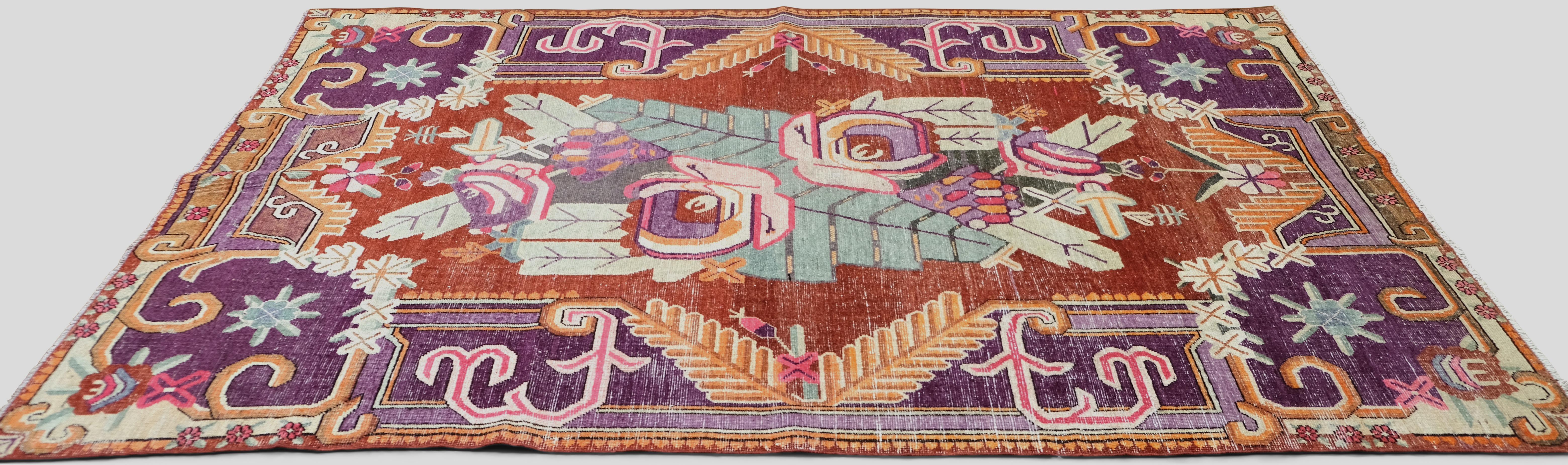 Add vibrant character to your space with this stunning vintage hand-knotted wool rug. Renowned for its intricate design and bold use of color, this rug features a central floral medallion framed by dynamic tribal and geometric motifs. The lively