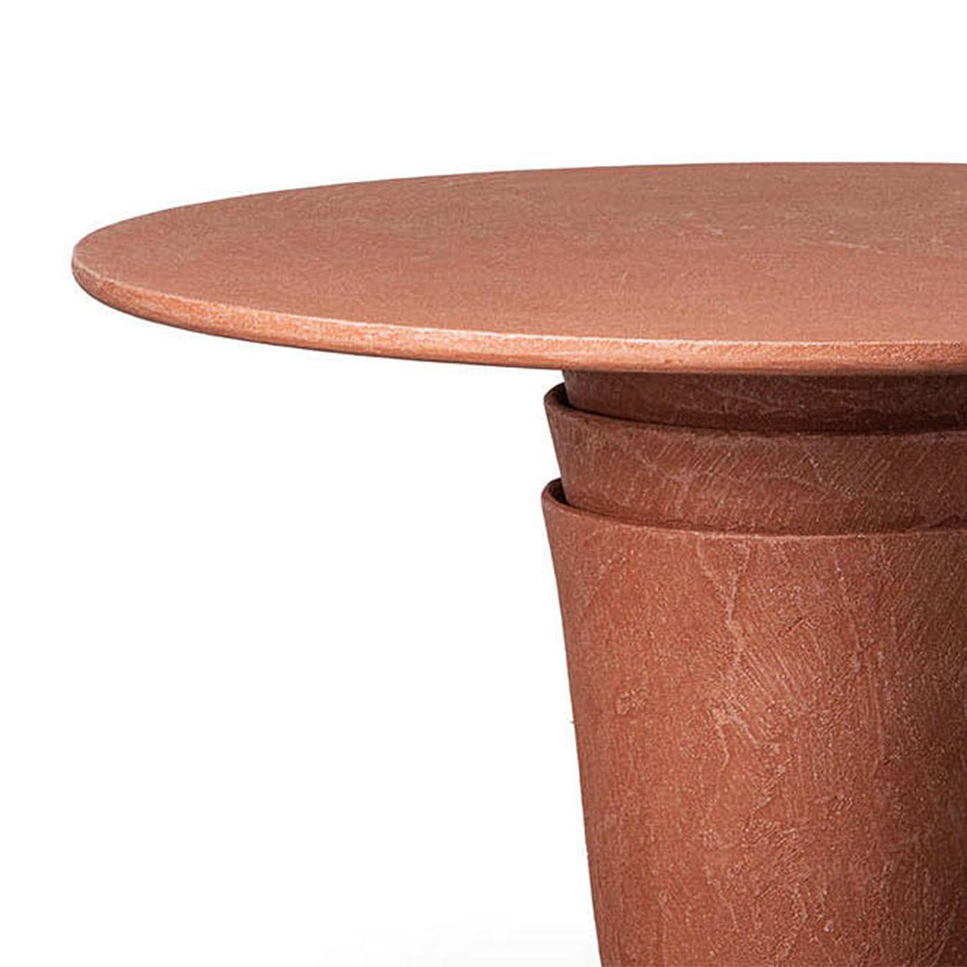 Table Vick Coral Round Outdoor avec plateau en bois en 
finition corail et avec base en résine polymère finition corail.
Également disponible en finition ciment, sur demande.