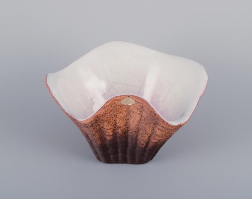 Vicke Lindstrand (1904-1983) for Upsala Ekeby.
Shell-shaped ceramic bowl. Glazed in brown tones with pink shades on the inside.
Model: 3037.
Marked.
In perfect condition with natural crackling from production.
Dimensions: D 21.0 cm x H 12.0 cm.