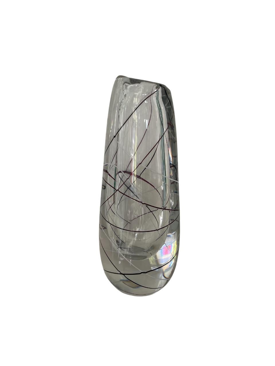 Élégant vase en verre d'art moderne du milieu du siècle, conçu par la célèbre artiste verrière suédoise Vicke Lindstrand pour Kosta Boda. Cette pièce remarquable présente une forme cylindrique claire et légèrement effilée avec un décor de fils