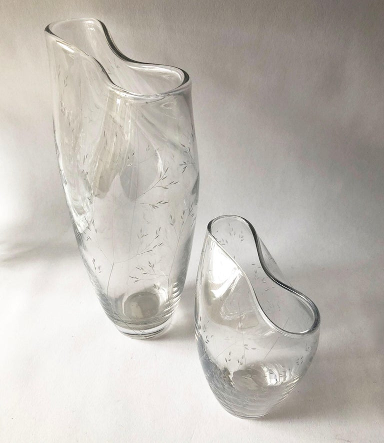 A pair of clear glass vases with etching of bamboo sprigs created by Vicke Lindstrand for Kosta. Vases measure 7