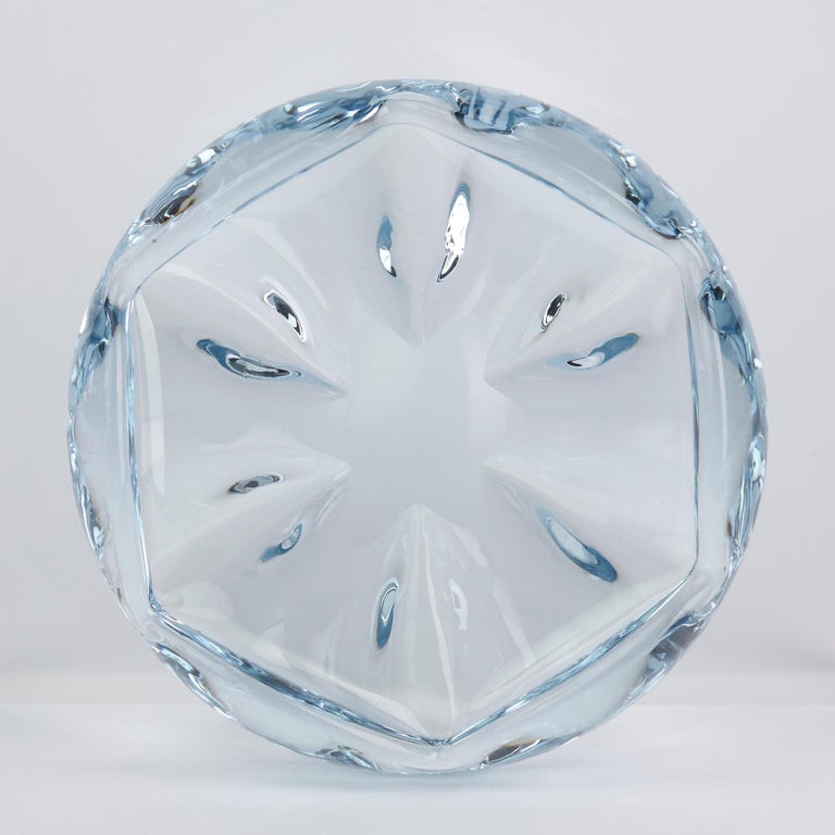A stunning and heavily made midcentury Swedish art glass Stella Polaris bowl designed by Vicke Lindstrand for Orrefors. The blown glass bowl is made in blue tinted glass and is of shallow rounded form in a floral like design. The bowl has a polished