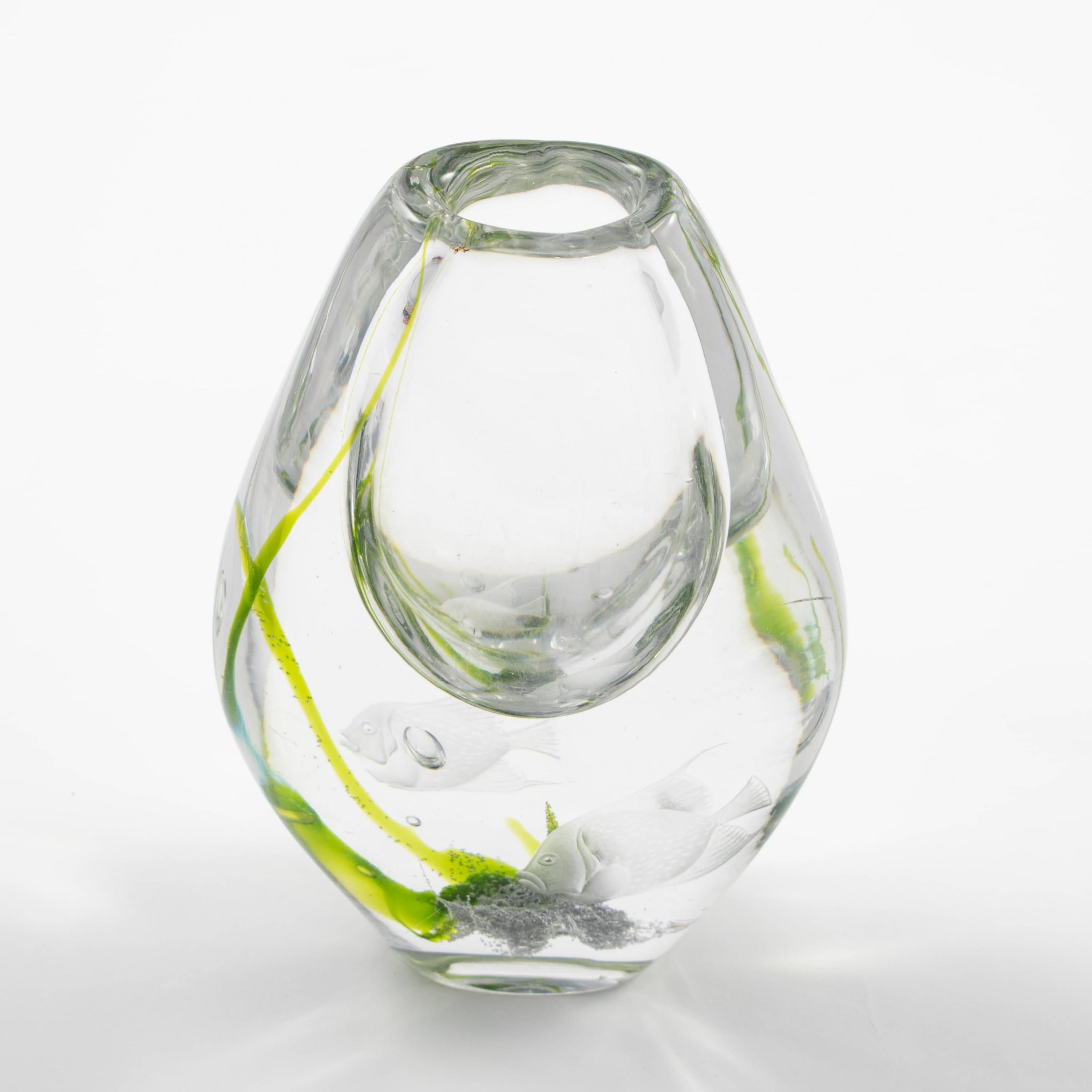 Vicke Lindstrand 1904-1983
Vaso in vetro disegnato da Vicke Lindstrand. Prodotto da Kosta in Svezia, negli anni '60.
Vetro trasparente con alghe verdi all'interno, inciso con una coppia di pesci.

Firmato sotto la base: 'Lindstrand. Kosta LG