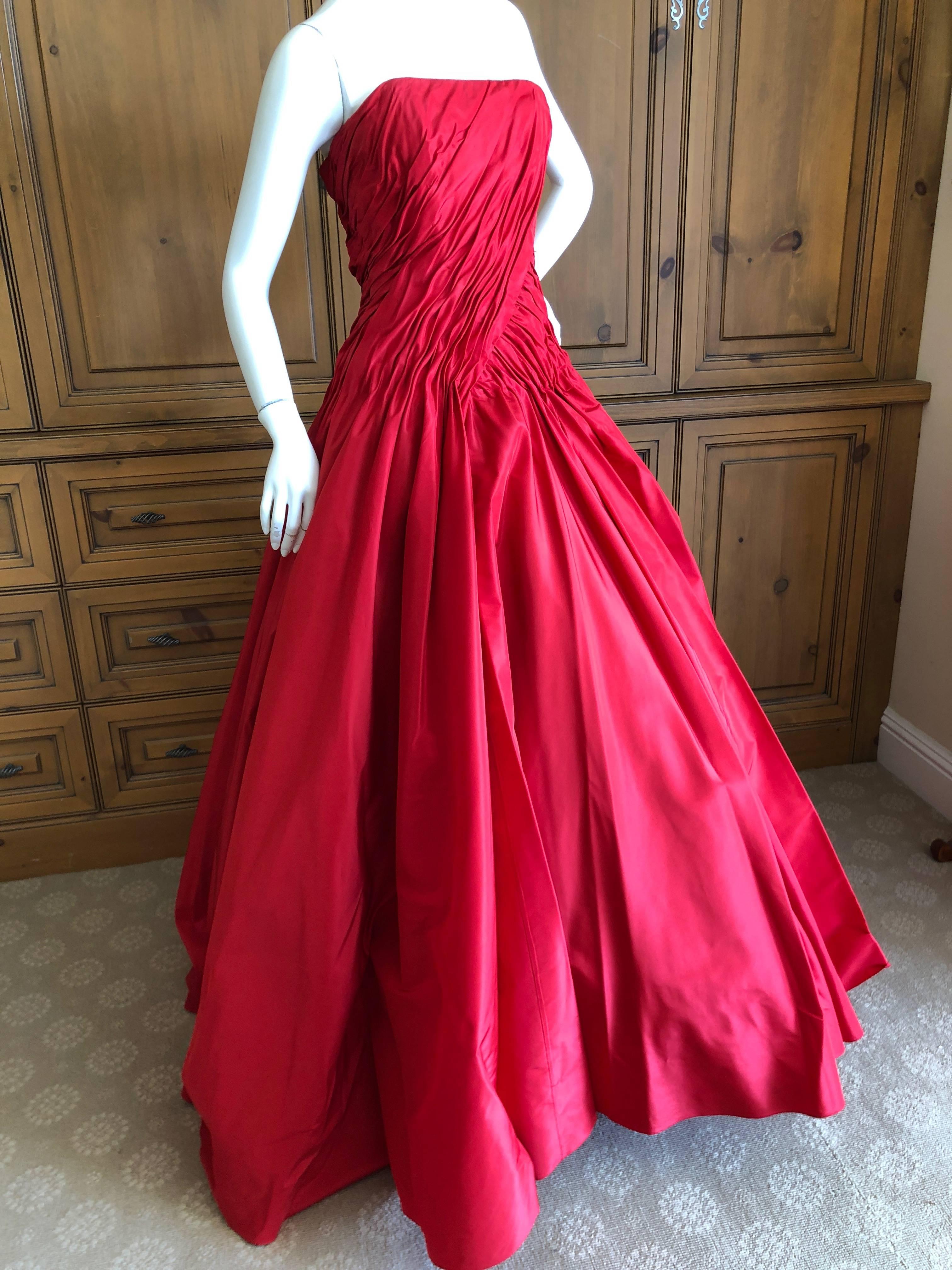 Wonderful red silk strapless evening gown from Vicky Teil Couture Paris.
This has a built in inner corset  and zips up the back.
There are four petticoats to hold the skirt full, and it stands by itself it is so fully constructed.
Please use the
